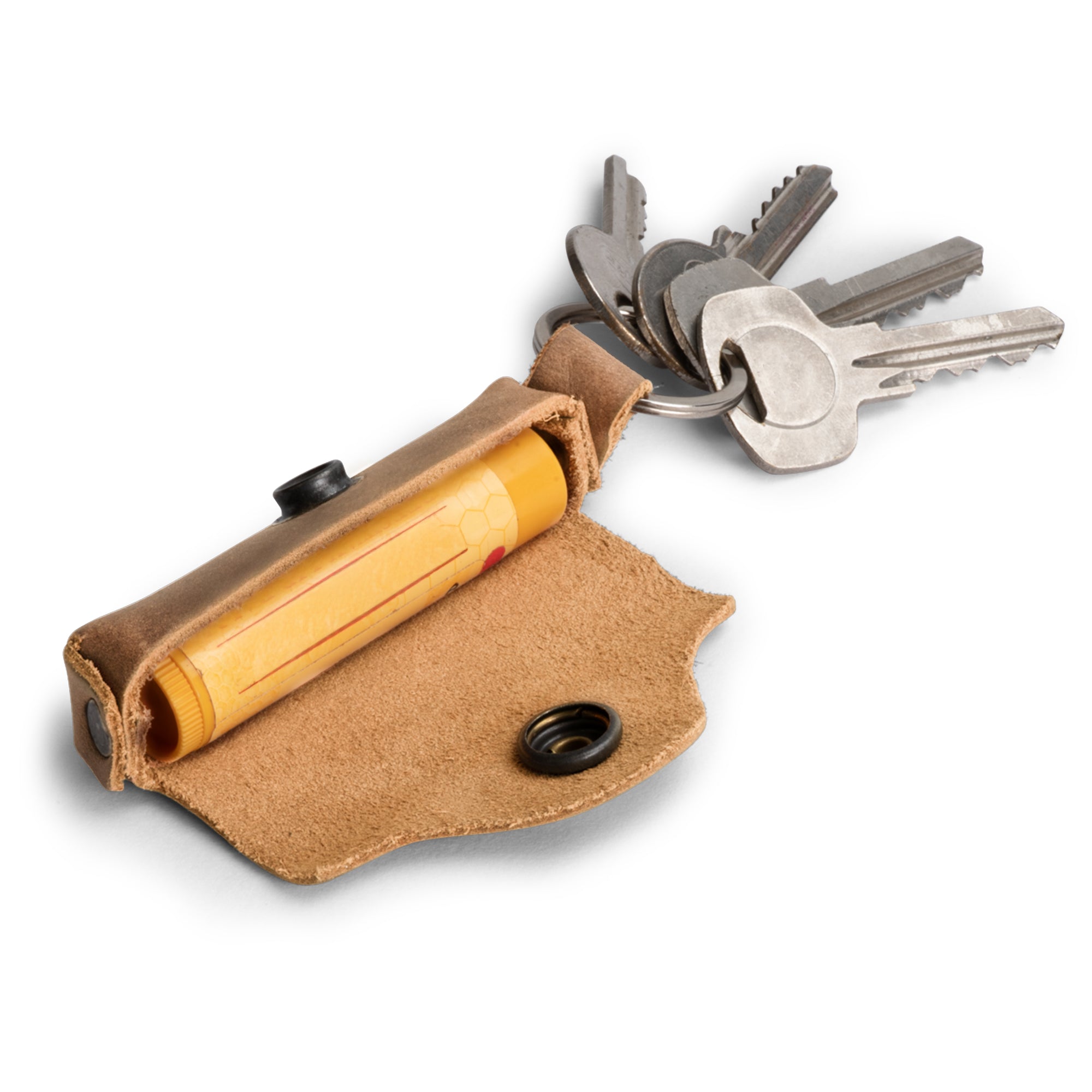 A rustic brown variant of the Lip Balm Key Chain from Hide & Drink, showing its capacity to securely hold a lip balm with keys. This classic vintage lip balm keychain holder is perfect for lip protection while maintaining style. Handcrafted from full grain leather, it embodies the artisan quality and unique touch found in products made in La Antigua Guatemala & Oaxaca Mexico.