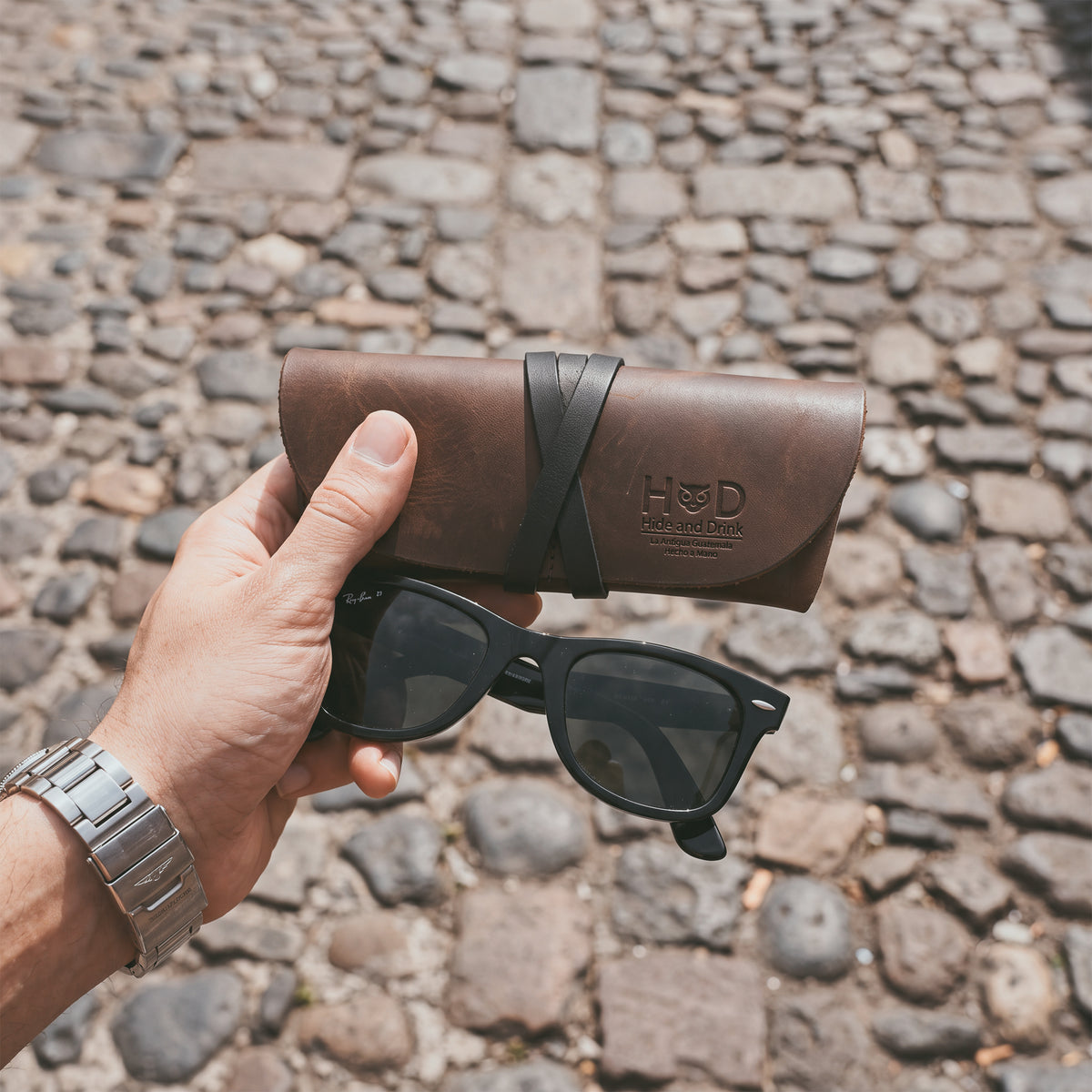 Hide & Drink Leather Sunglass Wrap comes with a stylish leather cord to secure your sunglasses. Crafted from full grain leather, it serves as an eye glasses storage solution, perfect for travel. This artisan-made product is hand cut and sewn, ensuring quality and durability.