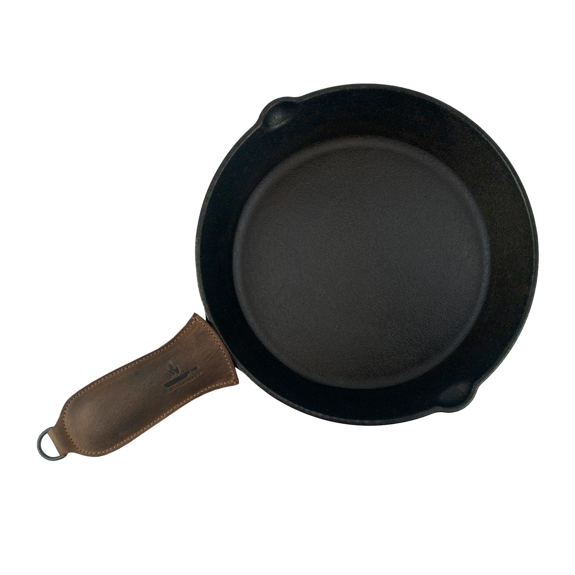 Hanging Pan Handle Cover by Cast Leather Co. displayed on a skillet, illustrating this functional Hot Handle Panhandle with Half Ring. Crafted from full grain leather for a perfect fit, it allows cookware to slide on/off easily onto metal skillet grips, showcasing artisan workmanship from La Antigua Guatemala & Oaxaca Mexico.