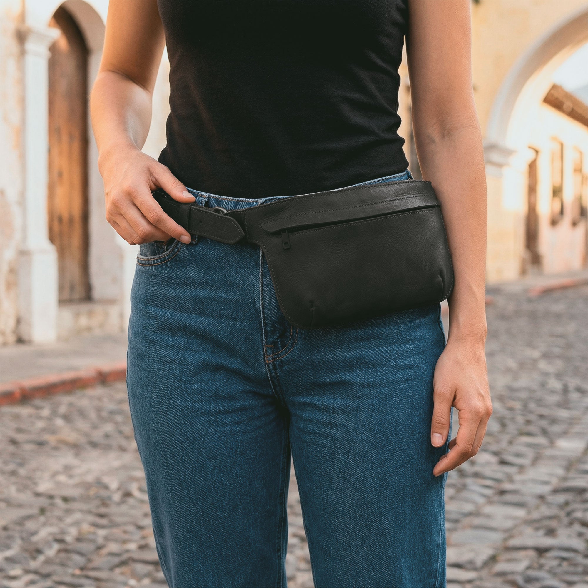Slim Fanny Pack by Hide & Drink in black leather, exemplifying a stylish rectangular design with an adjustable strap, perfect for carrying essentials like a phone. This handmade accessory is part of small batch artisan production in La Antigua Guatemala.