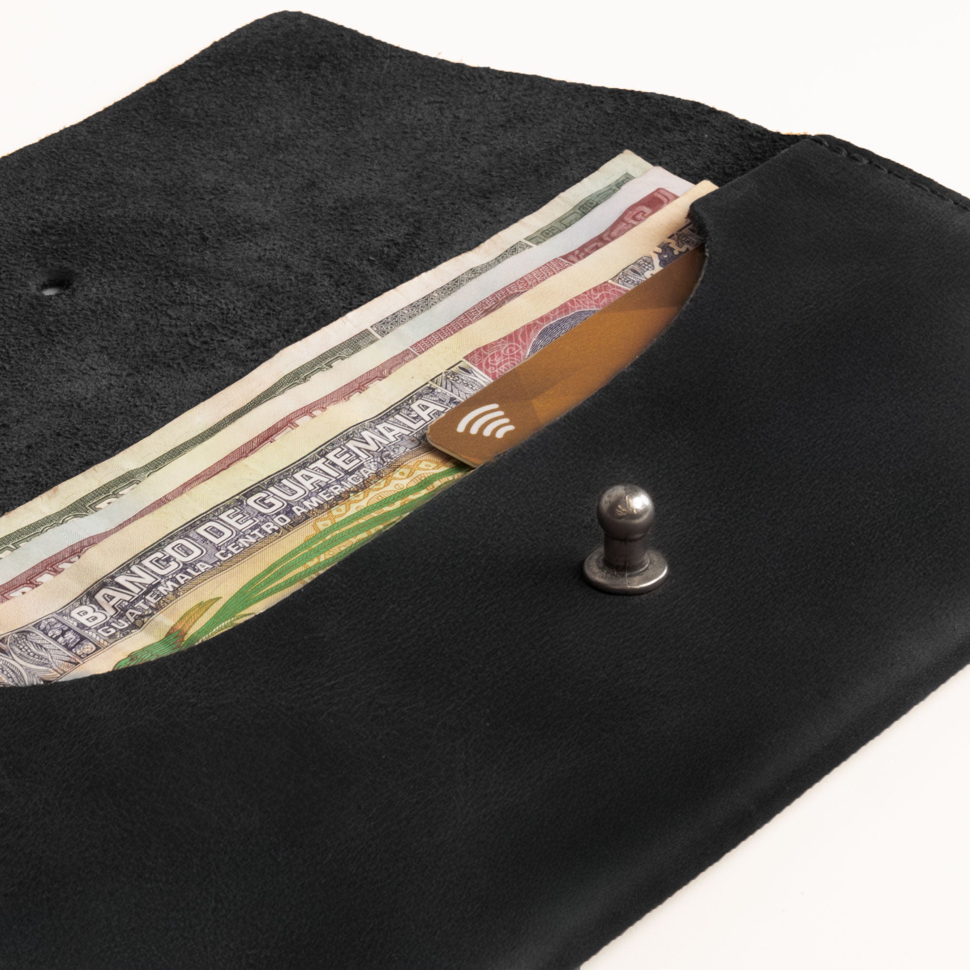 Close-up of the black Long Utility Pouch by Hide & Drink with coins inside, showcasing its practicality and style. Ideal for keeping coins, cash, and cards secure.