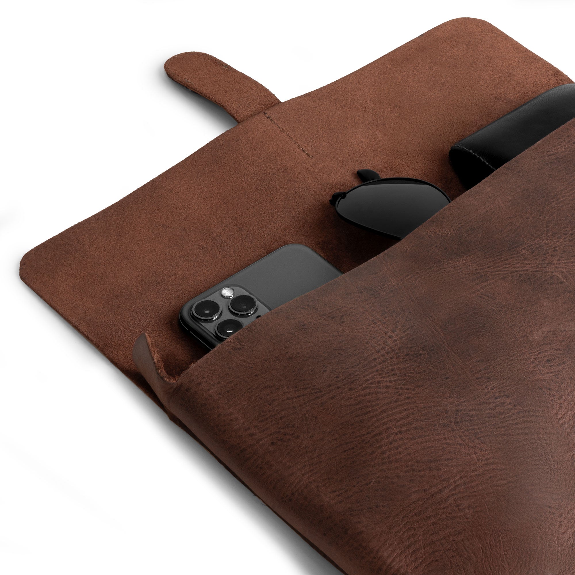 Close-up of the Hide & Drink Snapless Clutch Bag, featuring a spacious interior that fits a phone and sunglasses. This handmade accessory organizer is created from premium full grain leather, emphasizing artisan craftsmanship from La Antigua Guatemala, making it a great phone bag choice.