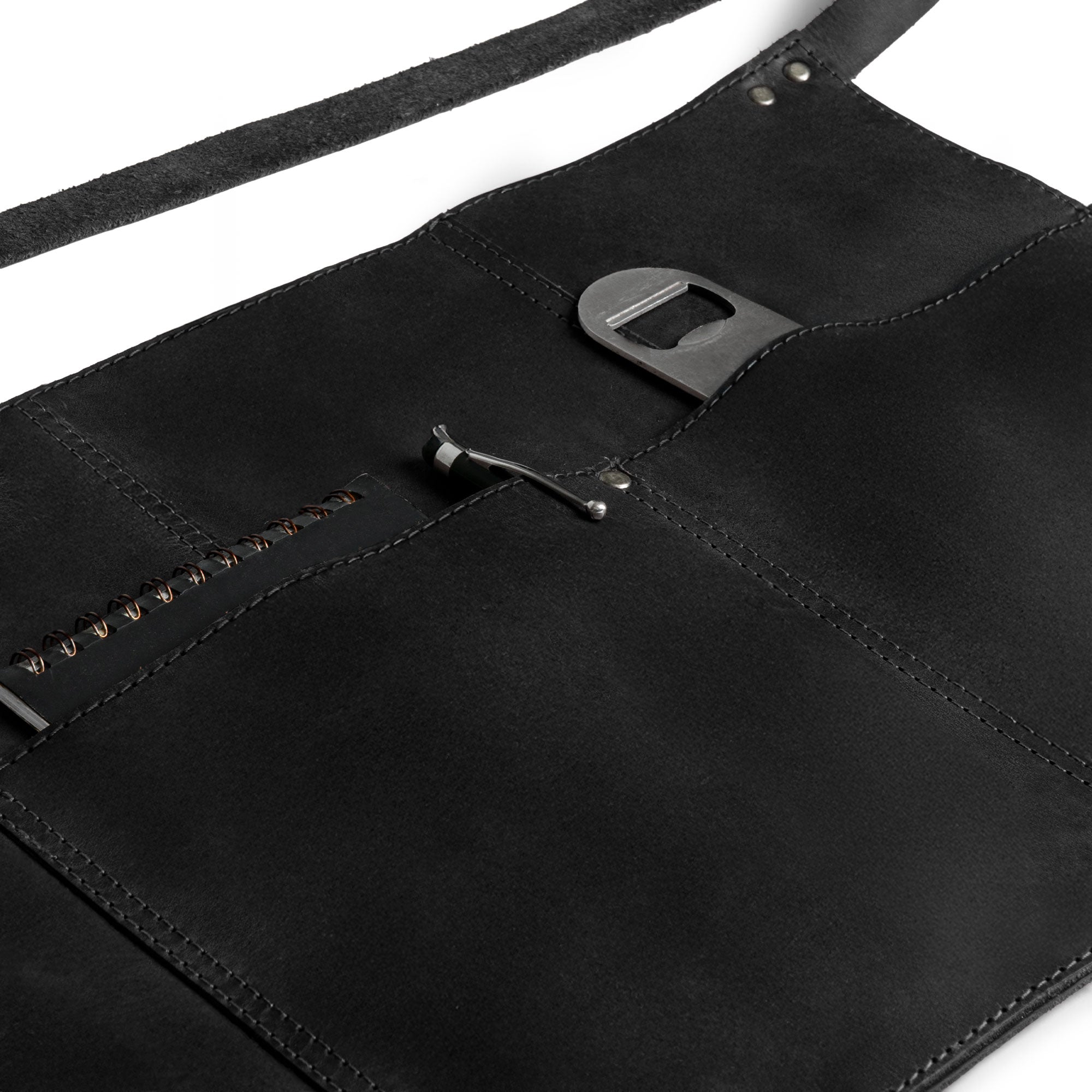 Close-up of the black Hide & Drink Barista Leather Waist Apron, featuring its riveted pockets and emphasizing its craftsmanship from full grain leather. Made in small batch production in La Antigua Guatemala & Oaxaca Mexico.