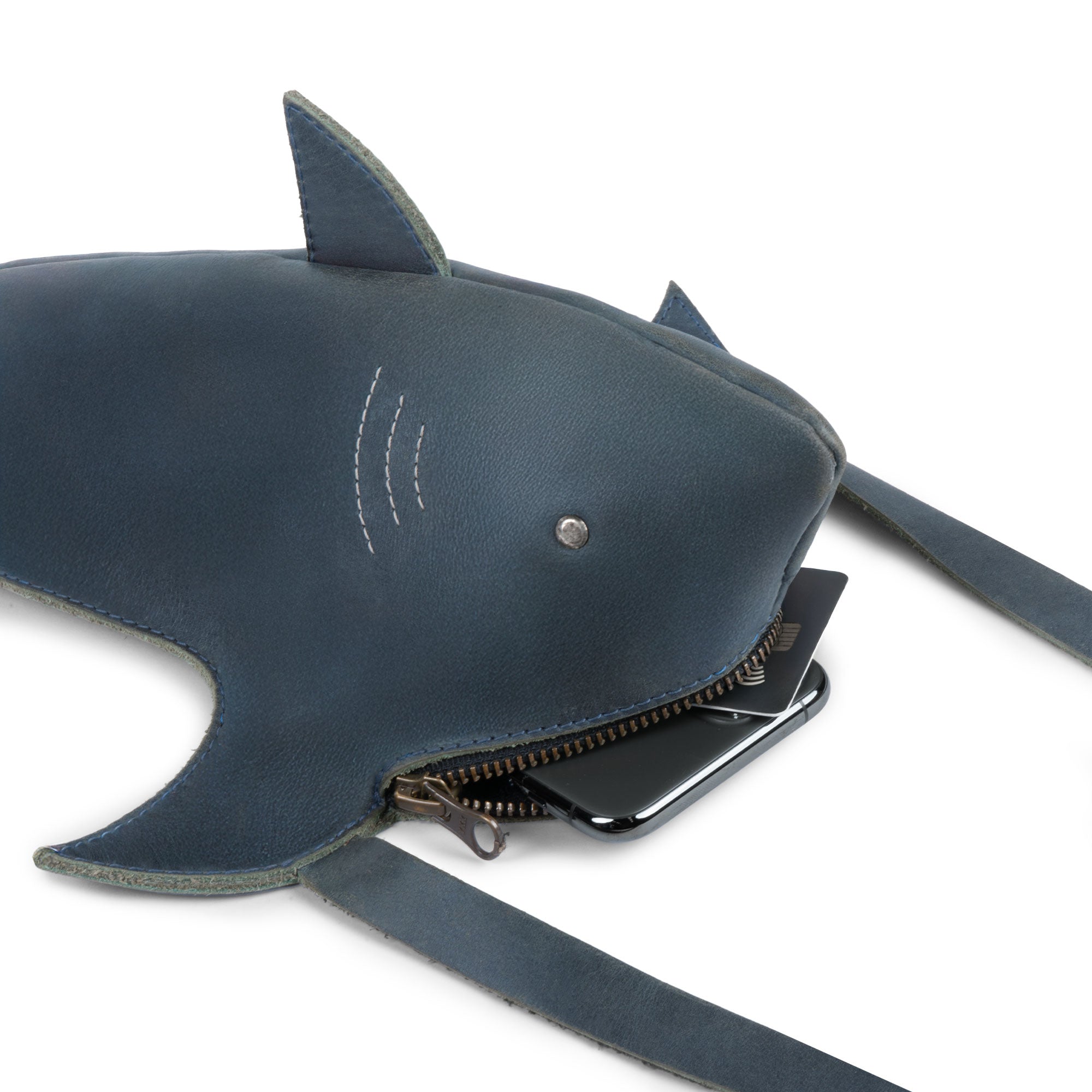 Tudi Frudi's Shark-Shaped Shoulder Bag showcases a unique shark design in full grain leather, featuring an adjustable strap for versatility as a Crossbody Shoulder Messenger Bag. Perfect for travel, this artisan-crafted piece is hand cut and sewn, highlighting the beauty of handmade in La Antigua Guatemala.