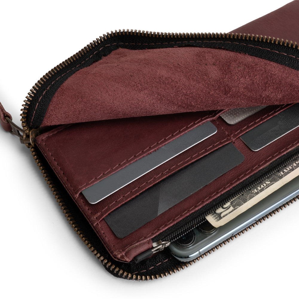 Open view of the Large Zippered Wallet by Hide & Drink in Sangria, showing its interior design with cash and cards. This Long Zippered Wallet for Men and Women serves as a Card Holder, Card Organizer, and Bill Holder, ideal for any traveler's needs. Hand cut and hand sewn in La Antigua Guatemala & Oaxaca Mexico, it highlights small batch production.