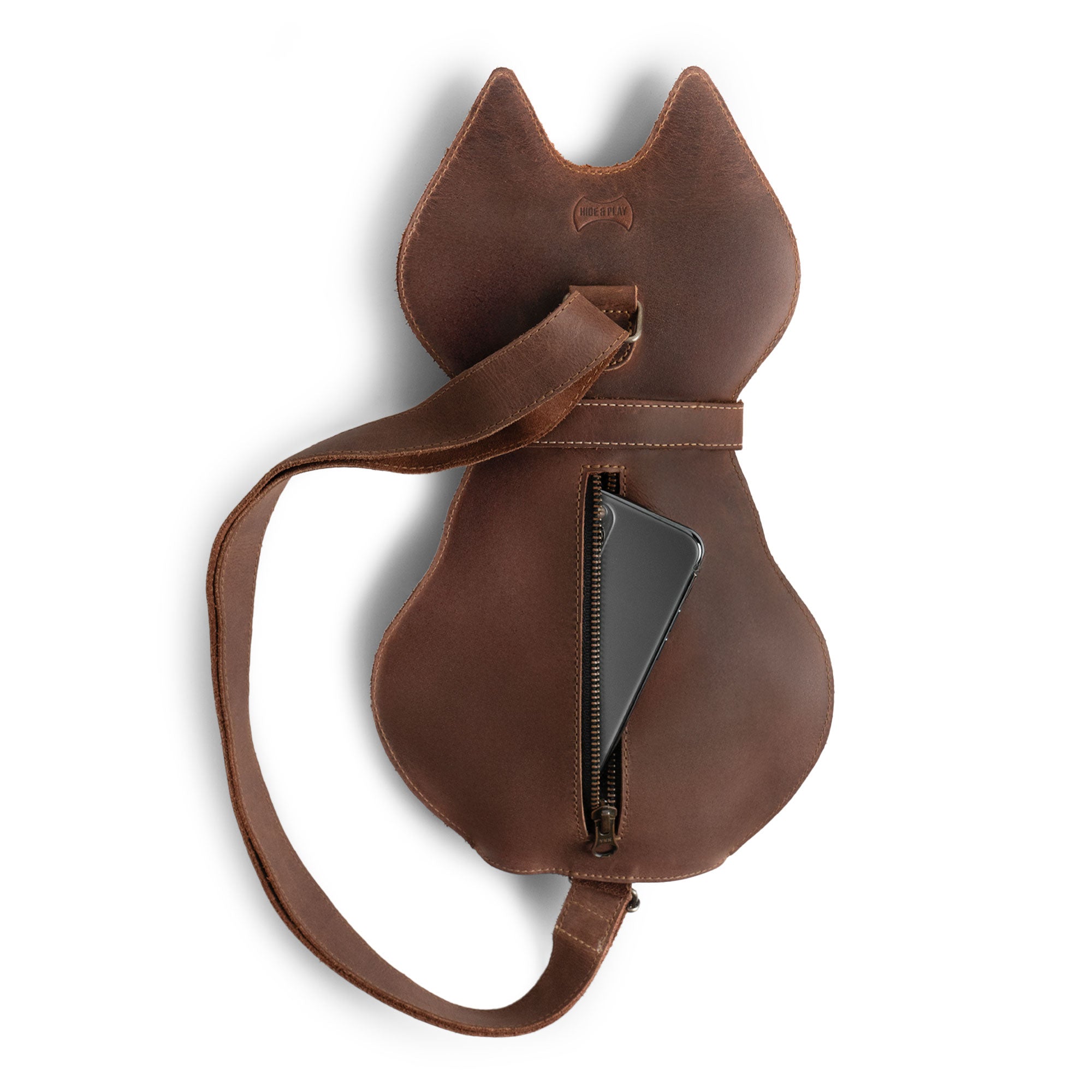 The Kitty Shape Backpack by Hide & Play, opened to show contents. Made from high-quality full grain leather, this handcrafted bag is perfect for pet lovers who want an accessory for travel or everyday use, featuring artisan details from La Antigua Guatemala.
