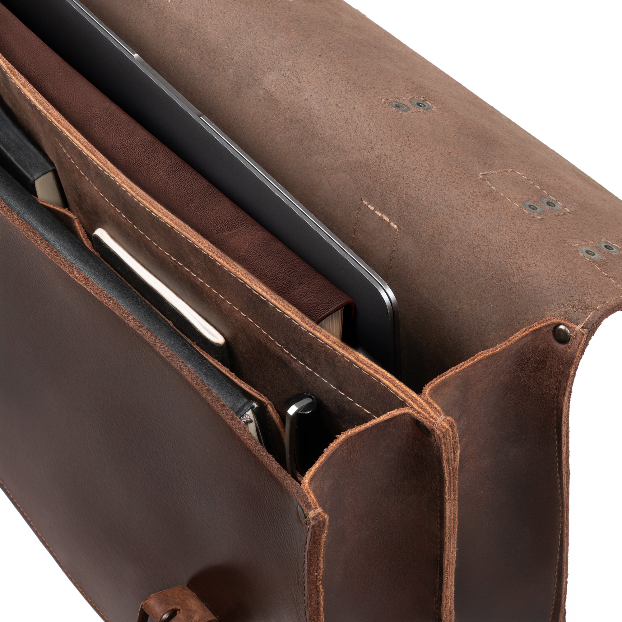 Close-up of the Hide & Drink 2-Compartment Thick Messenger Bag, highlighting its interior with dedicated compartments for laptops and accessories. This Rustic Briefcase with Adjustable Shoulder Strap is a Heavy Duty Satchel, perfect for travel. Made from Full Grain Leather, this Handmade accessory emphasizes Artisan quality from small batch production in La Antigua Guatemala & Oaxaca Mexico.