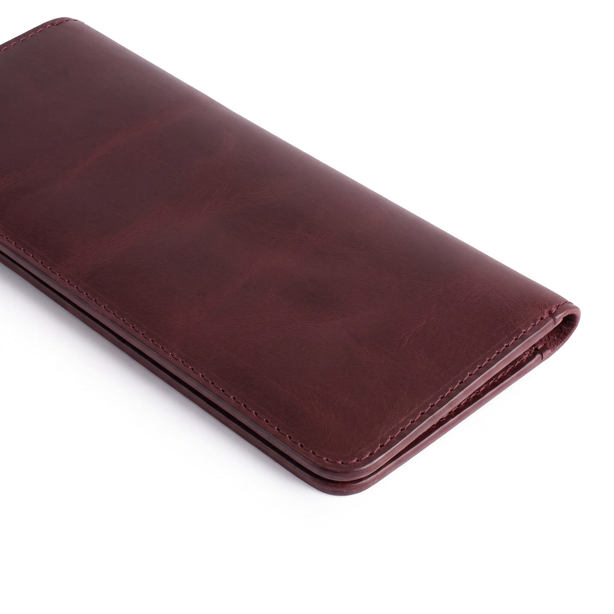 Closed red bifold wallet for cellphone by Hide & Drink, featuring a sleek design and durable Full Grain Leather. This Bifold Wallet for Cellphone is a great accessory that combines style and practicality, handcrafted through small batch production by talented artisans in La Antigua Guatemala & Oaxaca Mexico.