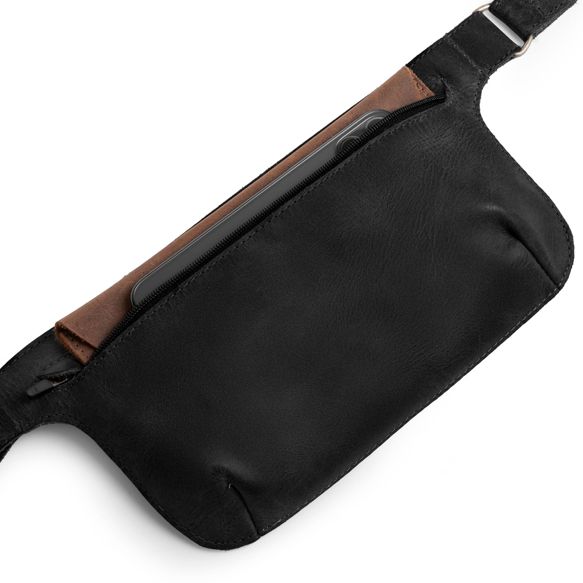 Slim Fanny Pack by Hide & Drink opened with keys and a phone visible, designed as a narrow waist bag to keep essentials secure. Made from high-quality full grain leather, this handmade accessory embodies artisan craftsmanship from La Antigua Guatemala.