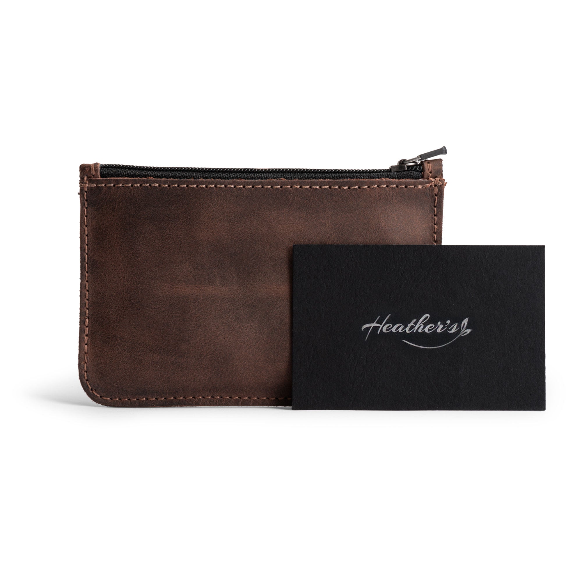 Heather's Zippered Half Wallet alongside a stylish card, illustrating its practical yet chic design. This full grain leather wallet is handmade in La Antigua Guatemala and is perfect for organizing everyday essentials like cards and cash. Experience quality artisan craftsmanship in every detail.