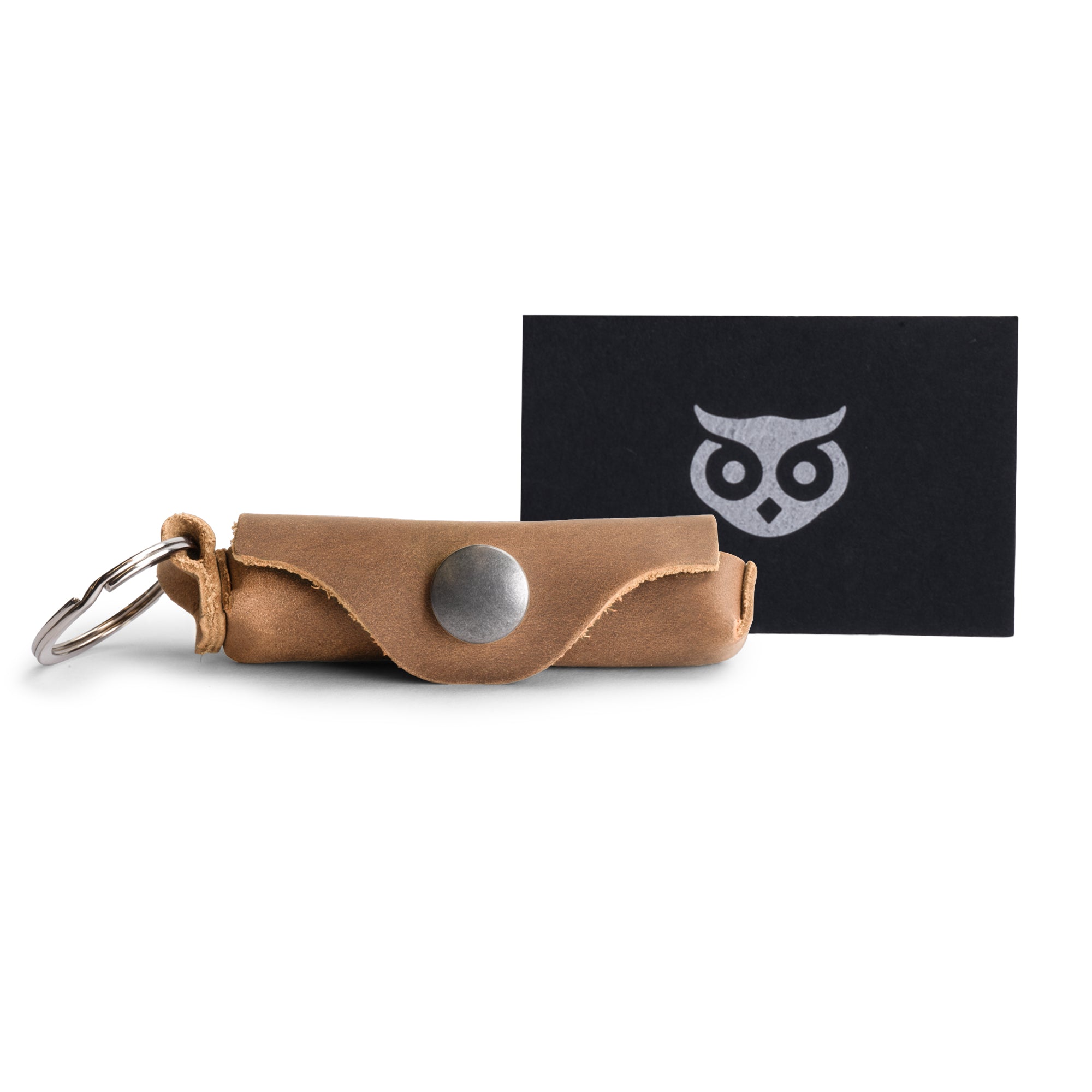 The Rustic Leather Lip Balm Key Chain by Hide & Drink alongside other unique keychain items. This Lip Balm Key Chain holder showcases the full grain leather material and classic vintage design, complemented by a brass metal clasp. Handcrafted in La Antigua Guatemala, it reflects artisan skills and small batch production.