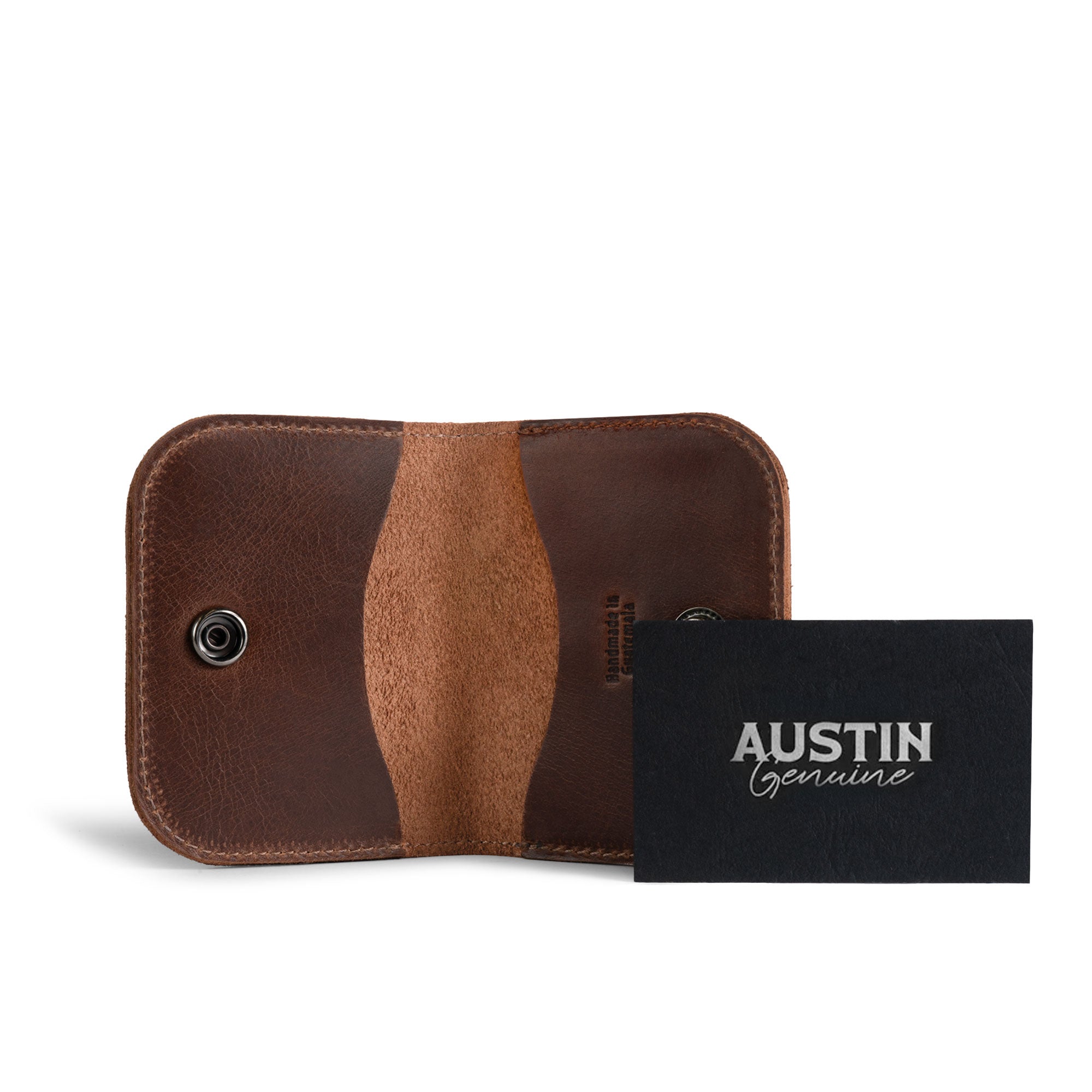 Open brown Austin Genuine The Magnolia Card Wallet beside its branded package, highlighting the leather interior and snap closure. The Magnolia Card Wallet is Full Grain Leather with StockyardX Small Batch Production, Hand Cut and Hand Sewn construction, Fire Branded Artisan character, and is Handmade in La Antigua Guatemala & Oaxaca Mexico.