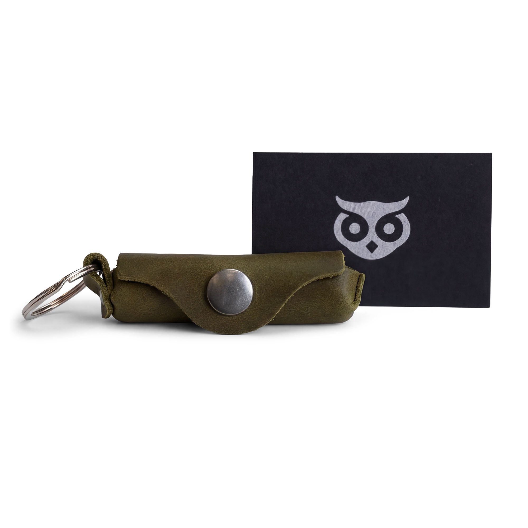 A collection of accessories including the Hide & Drink Lip Balm Key Chain displaying its artisan quality and design. This classic vintage lip balm keychain holder is perfect for securing your lip balm while providing excellent protection. Crafted from full grain leather with a brass metal clasp, it highlights the artistry of small batch production, handmade in La Antigua Guatemala & Oaxaca Mexico.