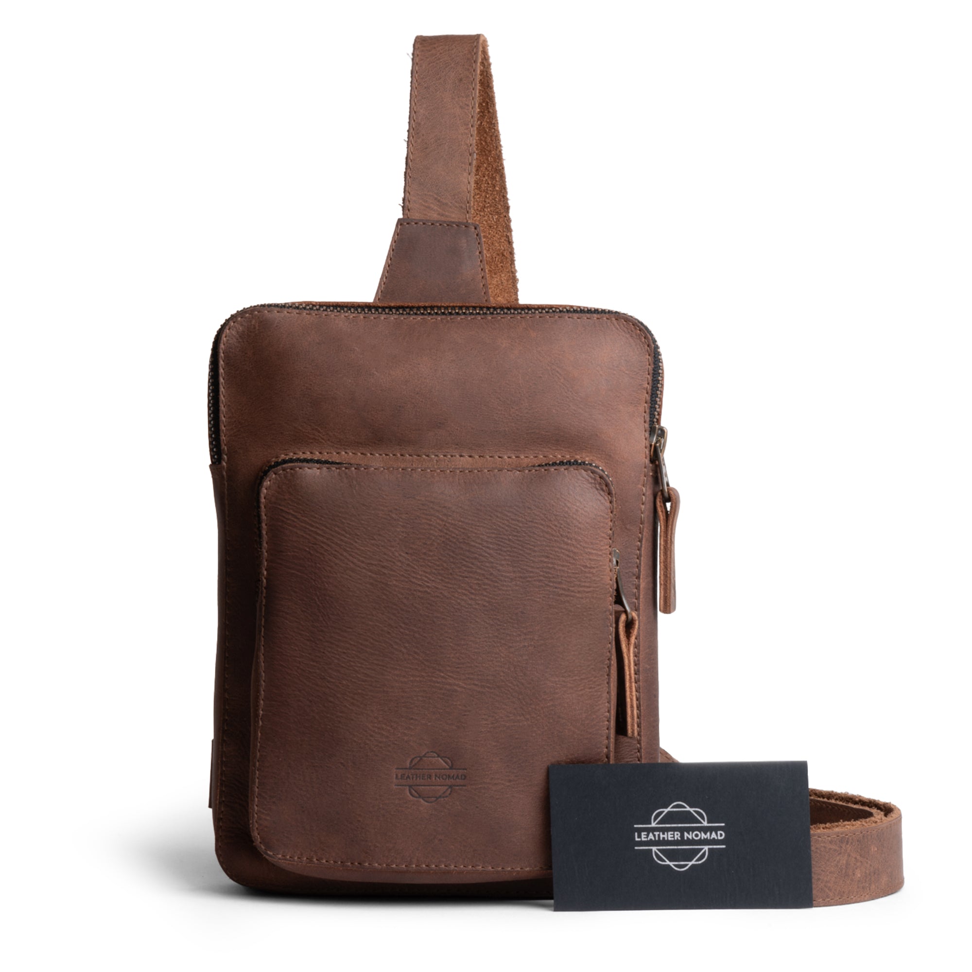 Traveler Sling Bag by Leather Nomad displayed with a business card, showing its fashionable and practical appeal. Made from full grain leather, this trendy bag is perfect for anyone looking for a stylish accessory. Artisan crafted in La Antigua Guatemala, it features unique touches from small batch production.