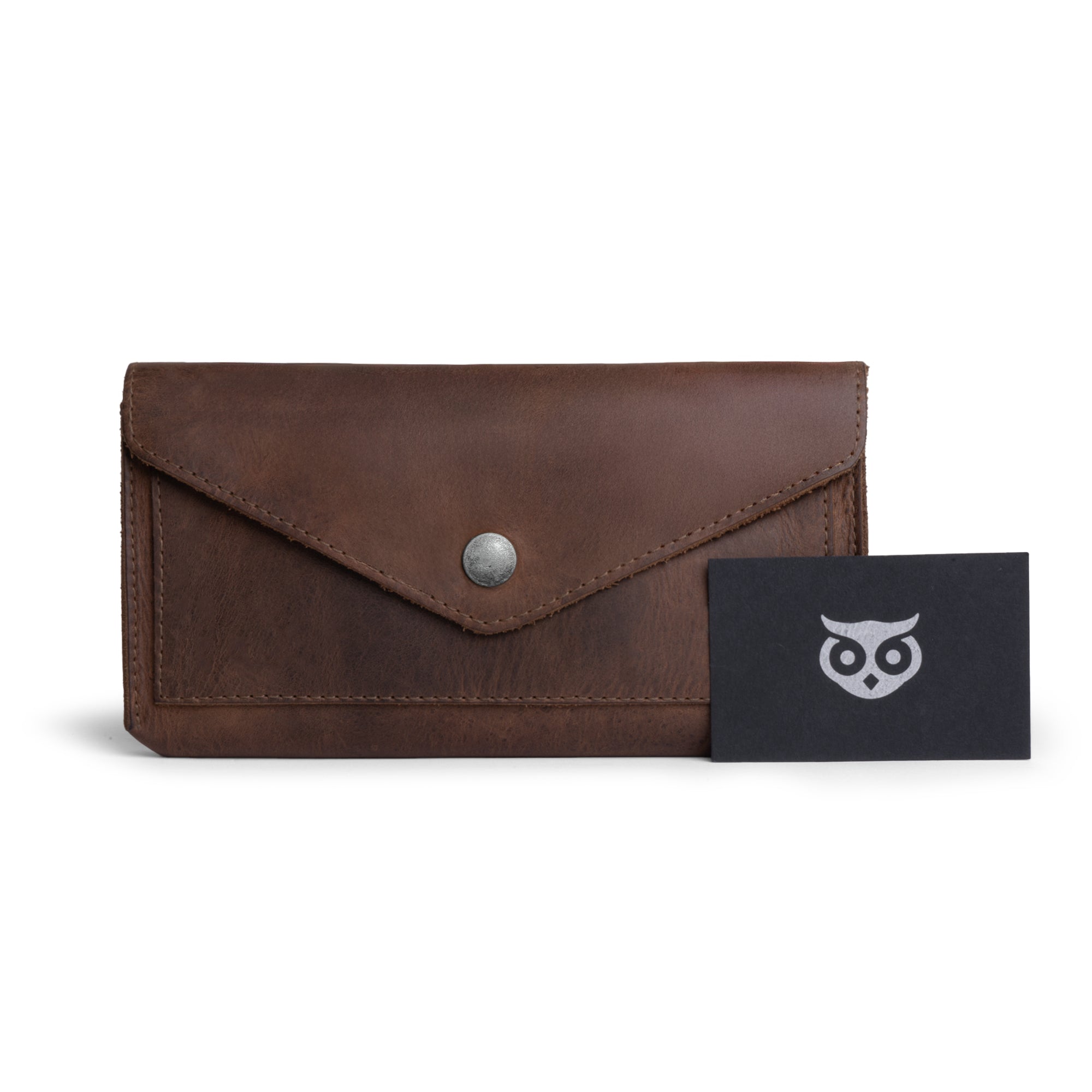 The Large Female Wallet by Hide & Drink displayed with its accompanying tags, emphasizing its authenticity and artisan quality. As a Travel Organizer for Women, this Vintage Money and Card Holder is made from Full Grain Leather, epitomizing Small Batch Production techniques and handcrafted quality, all Handmade in La Antigua Guatemala & Oaxaca Mexico.