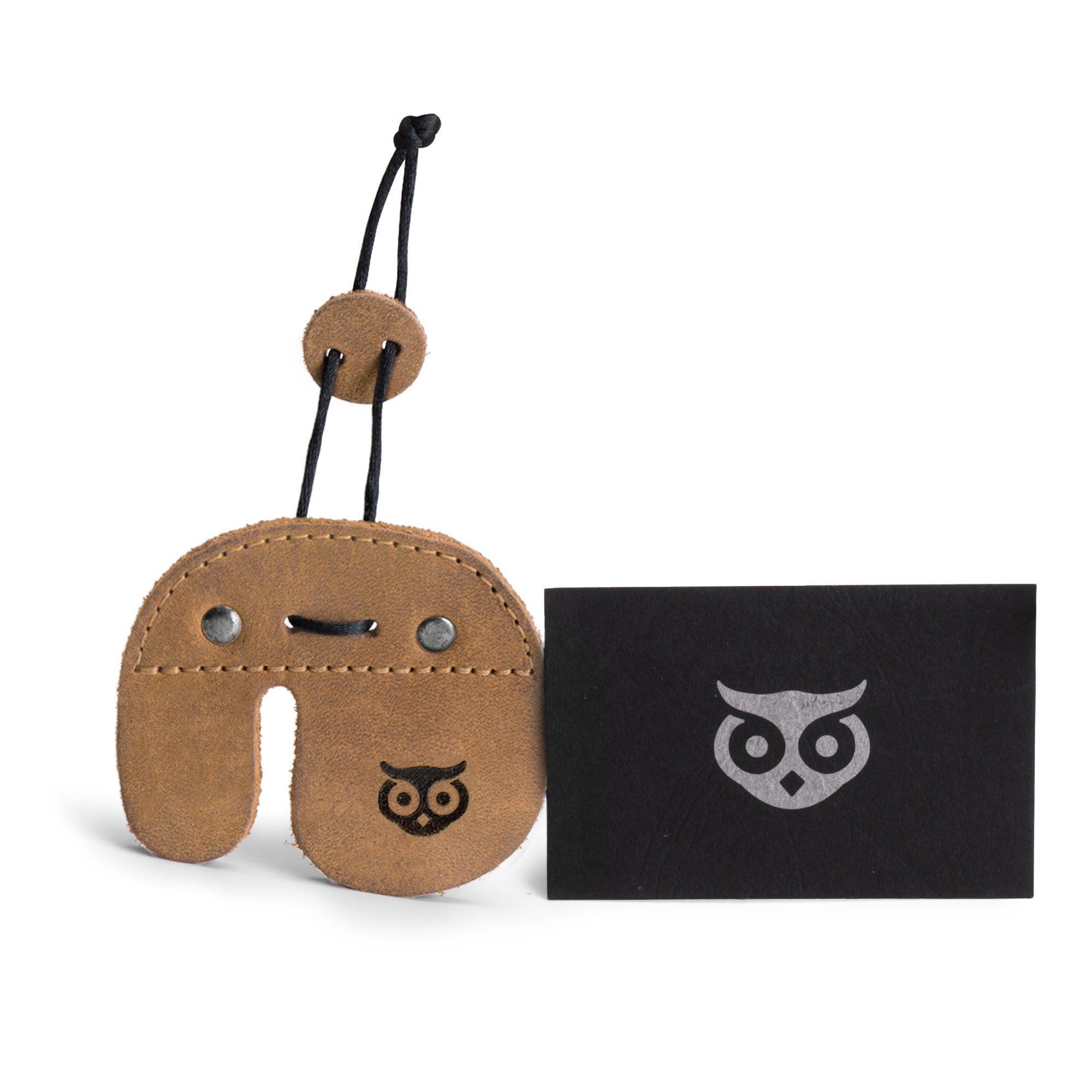 The Right Handed Archery Finger Protector from Hide & Drink, accompanied by a business card, emphasizing its artisan appeal. As an Archery Finger Tab made from Full Grain Leather, it serves as a Protect Guard for shooting practice gear and outdoor sports. This handmade product reflects the dedication of Small Batch Production, Hand Cut, Hand Sewn techniques, and fire branding, created in La Antigua Guatemala & Oaxaca Mexico.