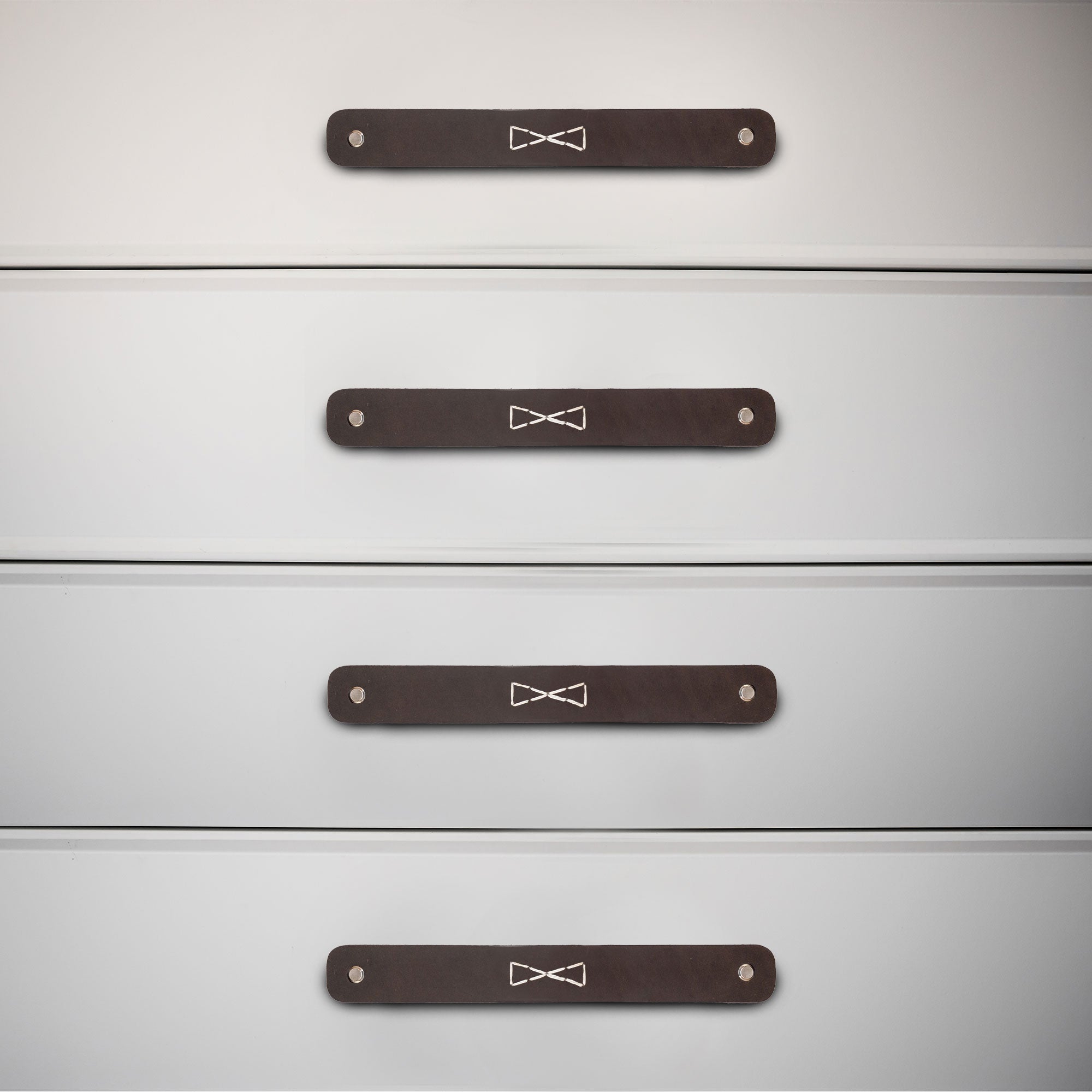 Rectangular Drawer Handles with Bowtie Stitching Design installed on a dresser, showcasing the craftsmanship of Hide & Drink. This 4 Pack of full grain leather handles adds a touch of handmade elegance from La Antigua Guatemala & Oaxaca Mexico.