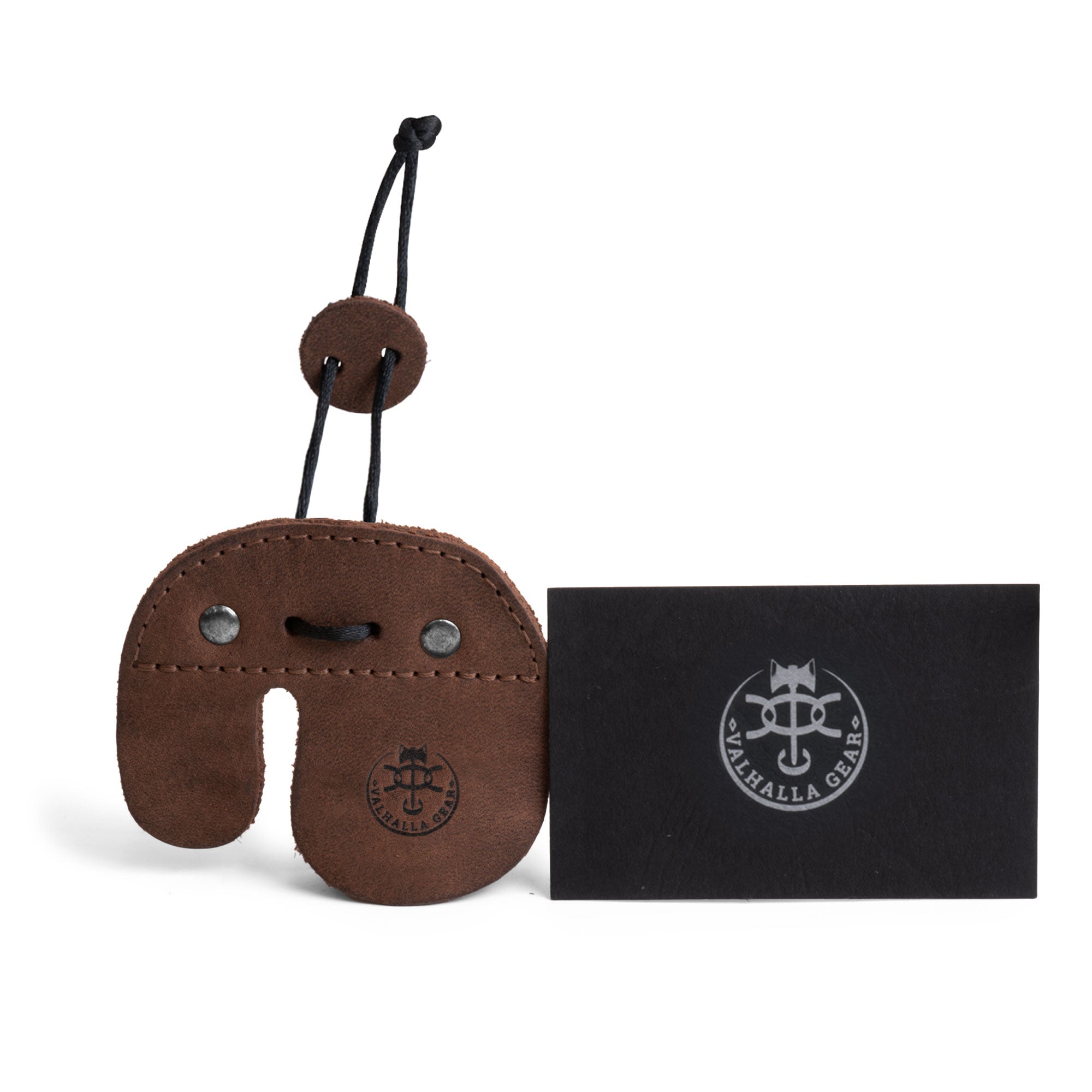 The Right Handed Archery Finger Tab by Valhalla Gear alongside a business card, showing both the product and branding. This premium finger protector, made from full grain leather, is perfect for shooting practice with recurve bows. Handmade in La Antigua Guatemala, it represents small batch production with a fire branded finish, ideal for outdoor sports lovers.