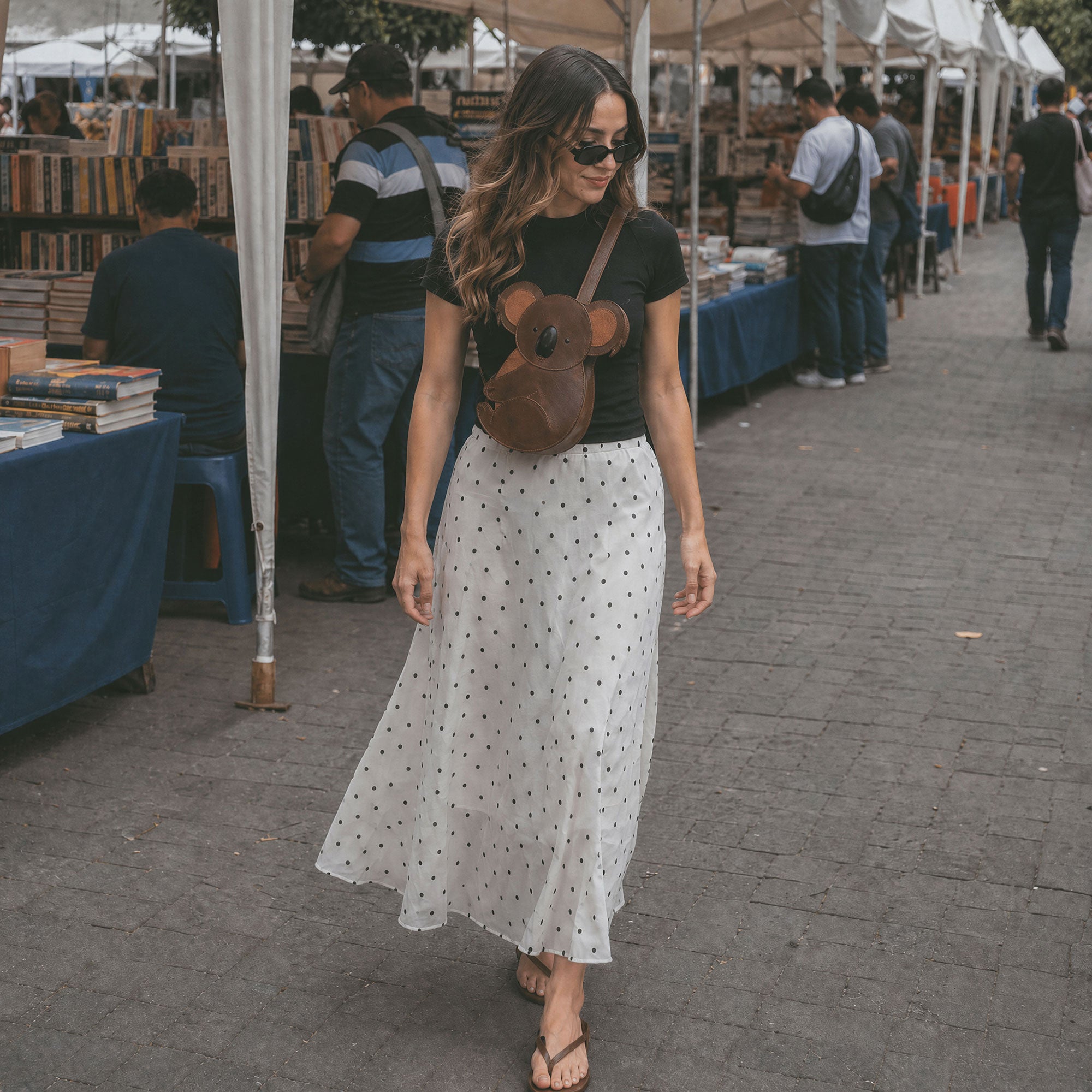 Lifestyle image of a woman wearing the Tudi Frudi Leather Koala Crossbody Bag, highlighting its stylish design. This versatile purse serves as a shoulder bag or messenger bag, showcasing high-quality full grain leather with artisan craftsmanship made in La Antigua Guatemala and Oaxaca Mexico.