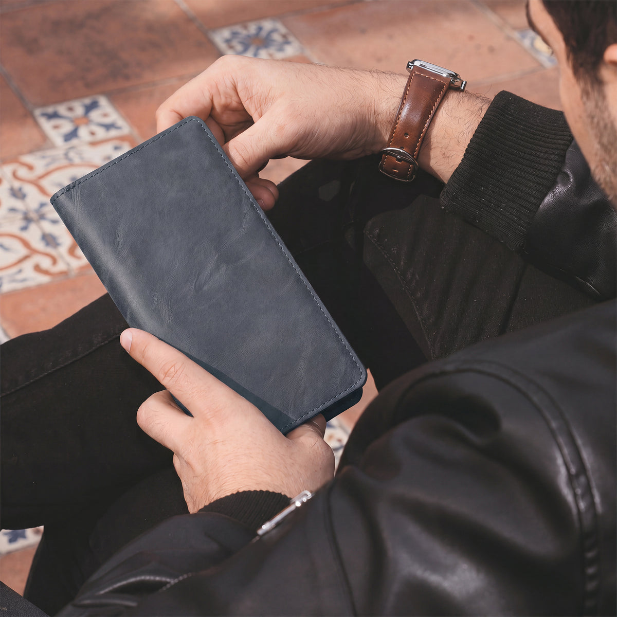 Closed view of the black bifold wallet for cellphone by Hide & Drink, showcasing its elegant and functional design. This Bifold Wallet for Cellphone made from Full Grain Leather is ideal for everyday use. Appreciate the artisan craftsmanship and small batch production from La Antigua Guatemala & Oaxaca Mexico.