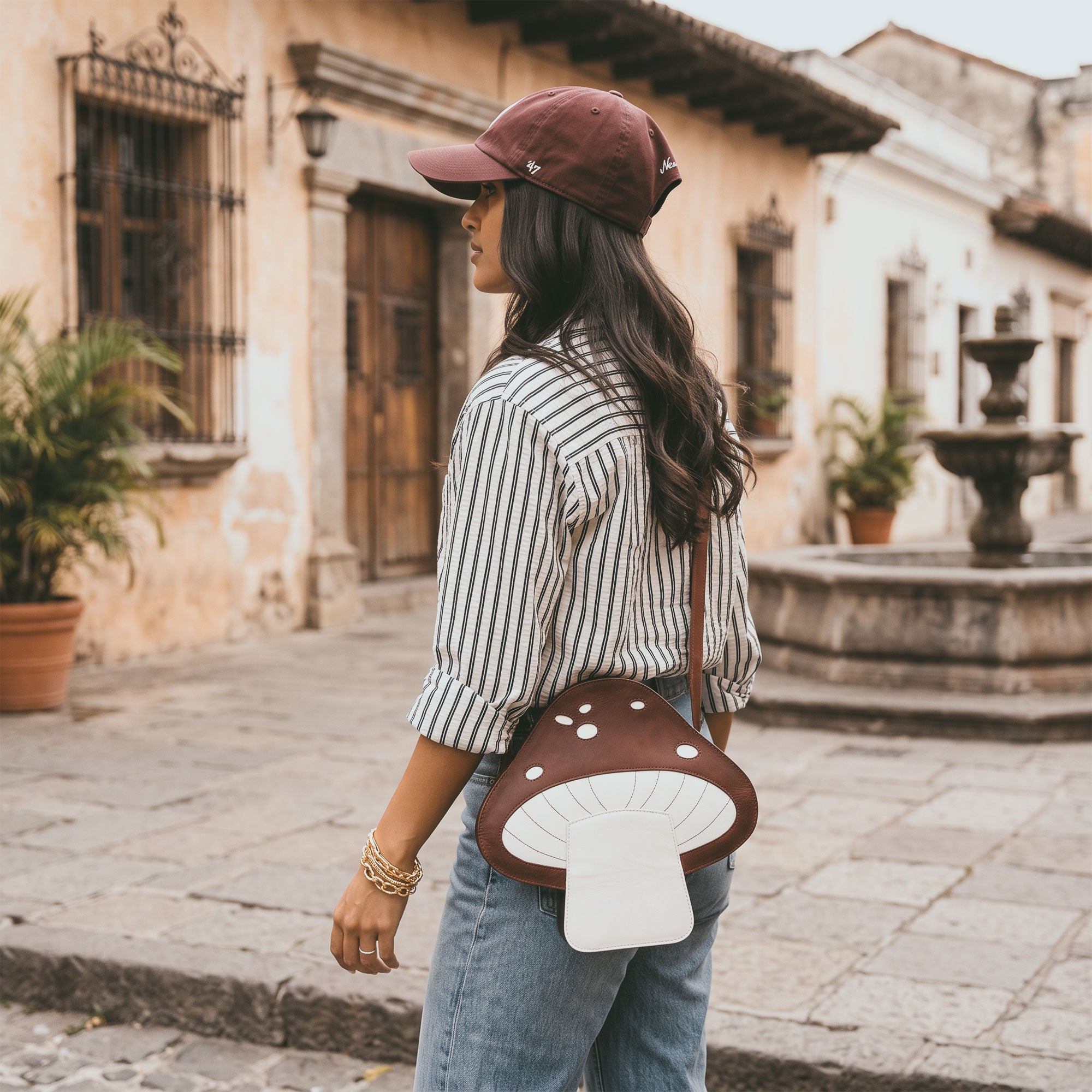 Mushroom-Shaped Leather Shoulder Bag by Tudi Frudi on a model, showcasing its unique style as both a crossbody and messenger bag. Crafted from Full Grain Leather, this handmade accessory is a perfect example of stockyardX's commitment to small batch production and artisan quality in La Antigua Guatemala.