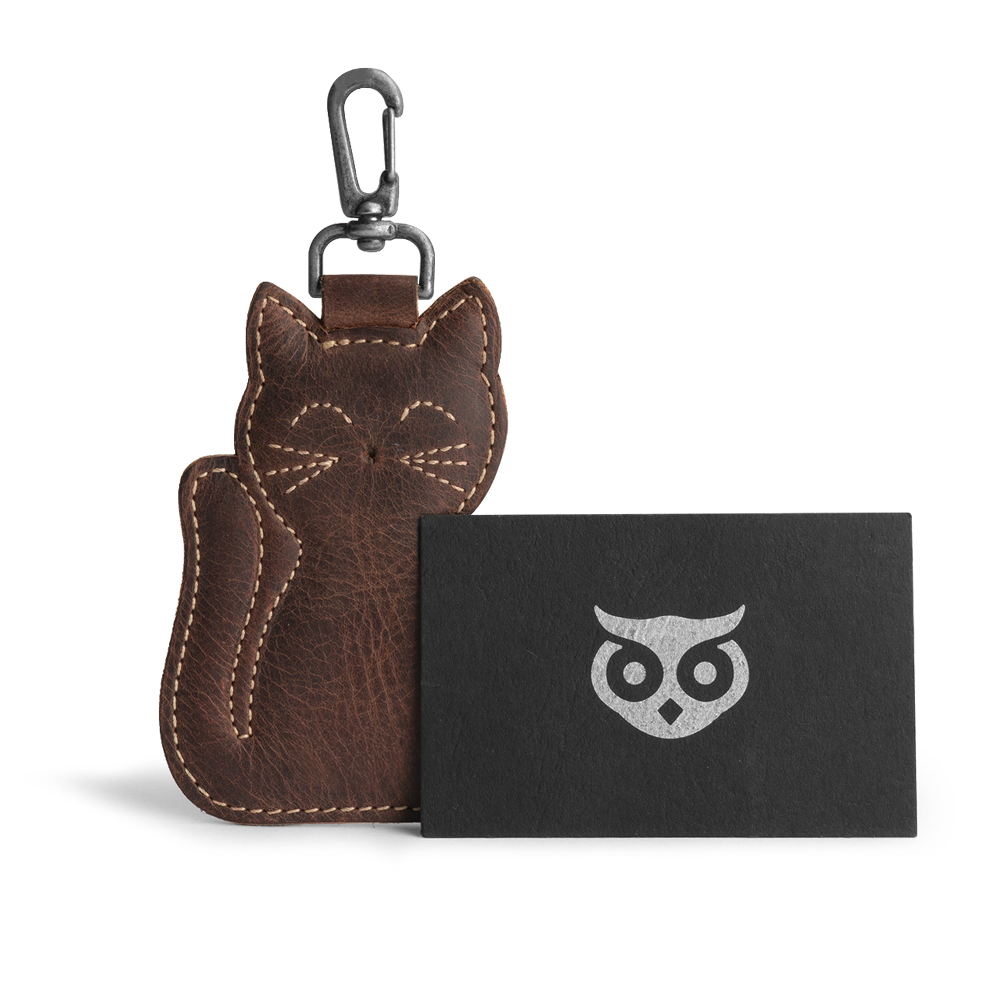 The Cat Keychain by Hide & Drink shown with its brand card. This Cat-Shaped Keychain serves as a practical key organizer and an adorable stuffed animal-shaped ornament, crafted from premium Full Grain Leather. Handmade in La Antigua Guatemala and Oaxaca, Mexico, it showcases artisan craftsmanship with its hand cut, hand sewn details and a distinctive fire-branded logo.