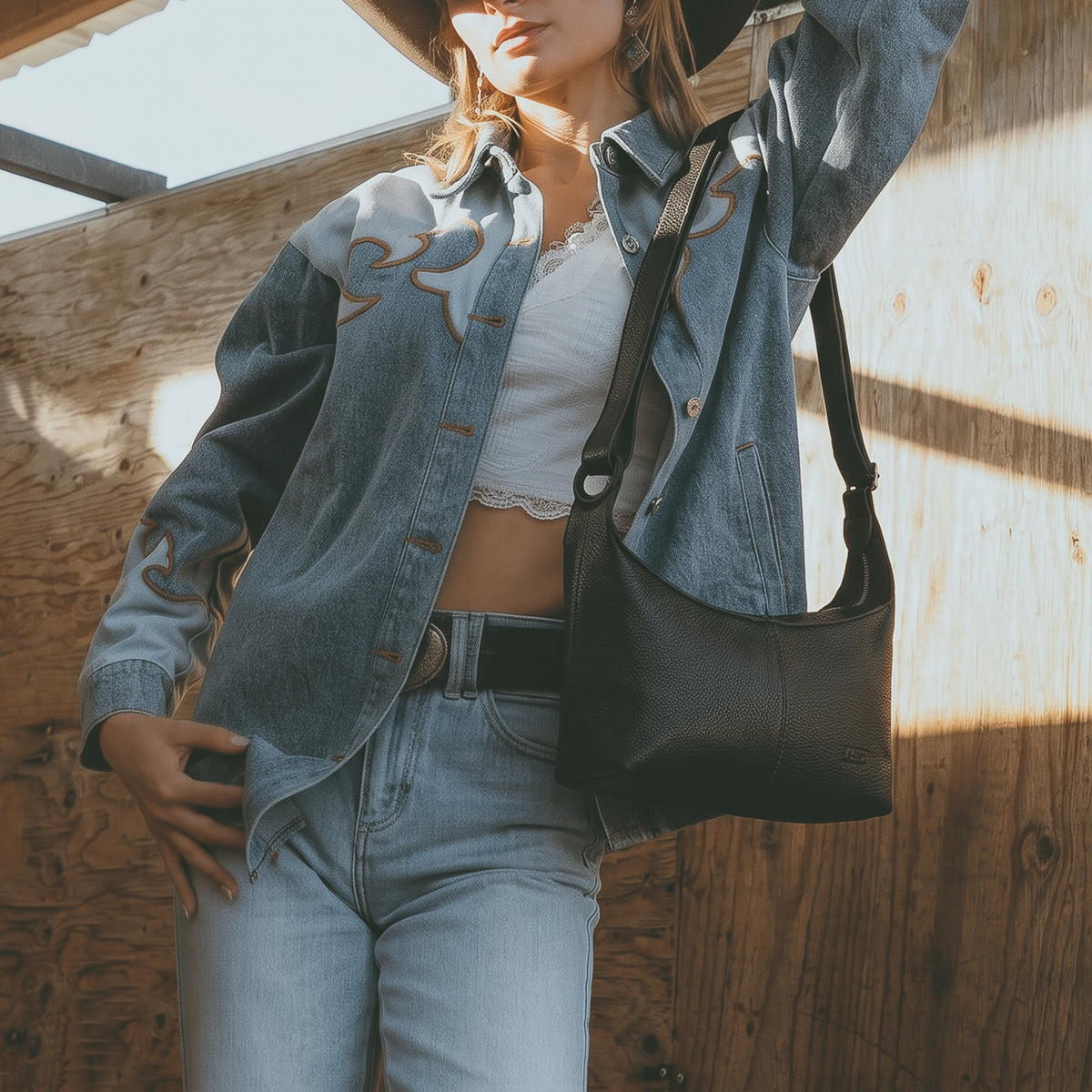 Austin Genuine The Mueller Hobo Shoulder Bag black Full Grain Leather dimensions diagram showing its shoulder strap and compact profile, featuring StockyardX Artisan design with Small Batch Production, Hand Cut, Hand Sewn, Fire Branded details, Handmade in La Antigua Guatemala & Oaxaca Mexico.