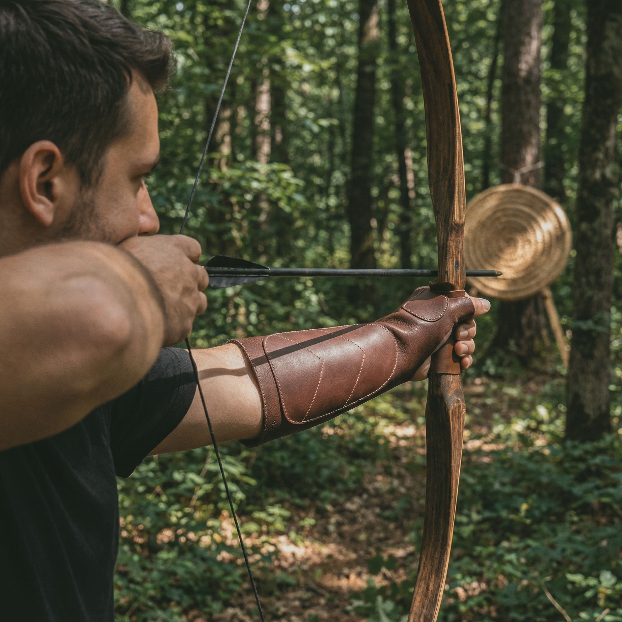 Archer preparing to shoot wearing The Bowmaster, Forearm Guard for Archers by Valhalla Gear. This professional full grain leather protective gear provides essential bow armguard protection while maintaining a comfortable grip for shooting accuracy. Ideal for both beginners and experienced archers, it symbolizes small batch production and artisan craftsmanship from La Antigua Guatemala and Oaxaca Mexico.