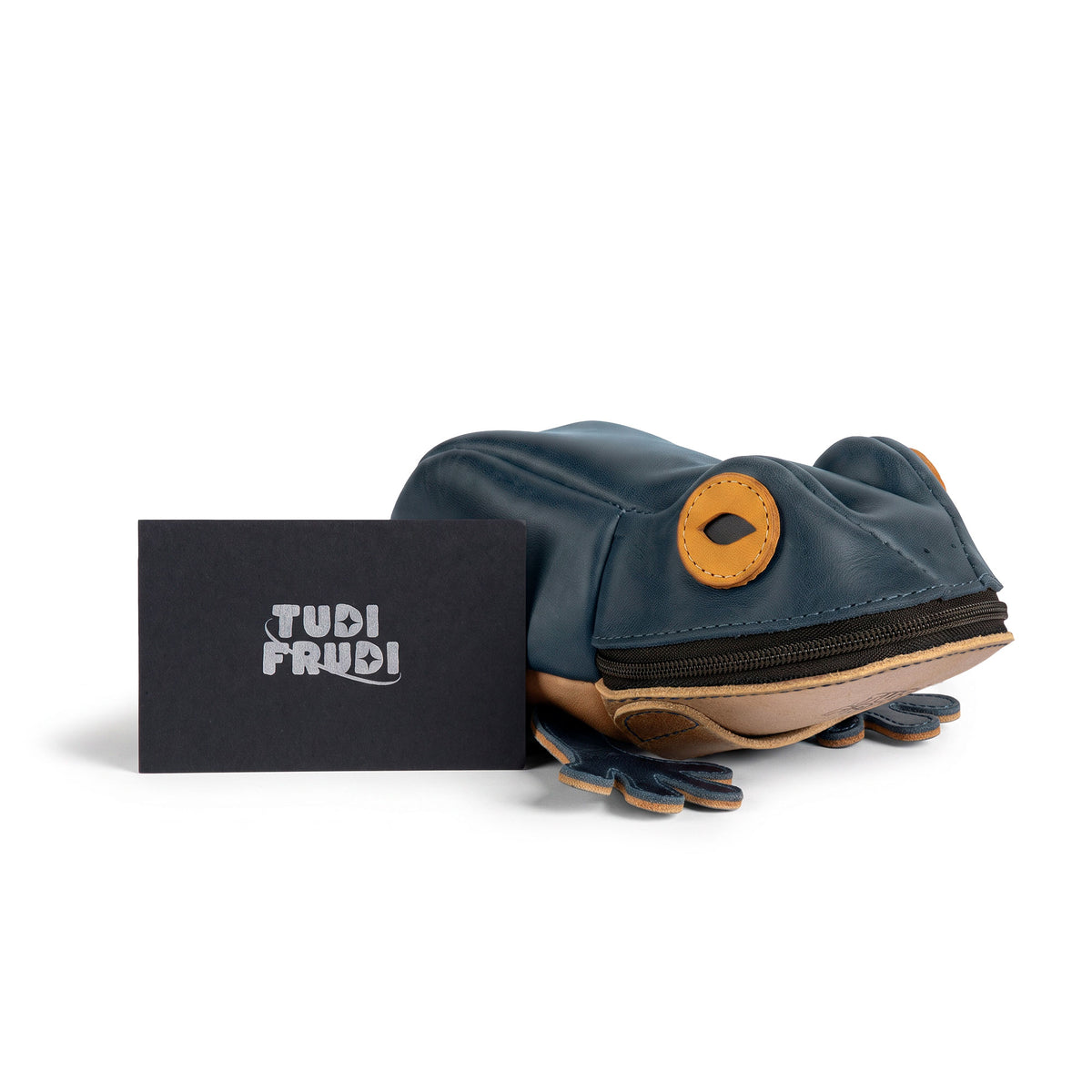 Tudi Frudi Frog Pouch displayed beside branded packaging, a Frog-Shaped Pouch that functions as a Cable Organizer, Small Accessory Case, Zippered Cash Holder Wallet for Coins, or Change Purse. Designed as Pouches for Men and Women, this Full Grain Leather accessory is made through StockyardX Small Batch Production, Hand Cut and Hand Sewn by Artisan makers, Handmade in La Antigua Guatemala & Oaxaca Mexico, with a Fire Branded finish.