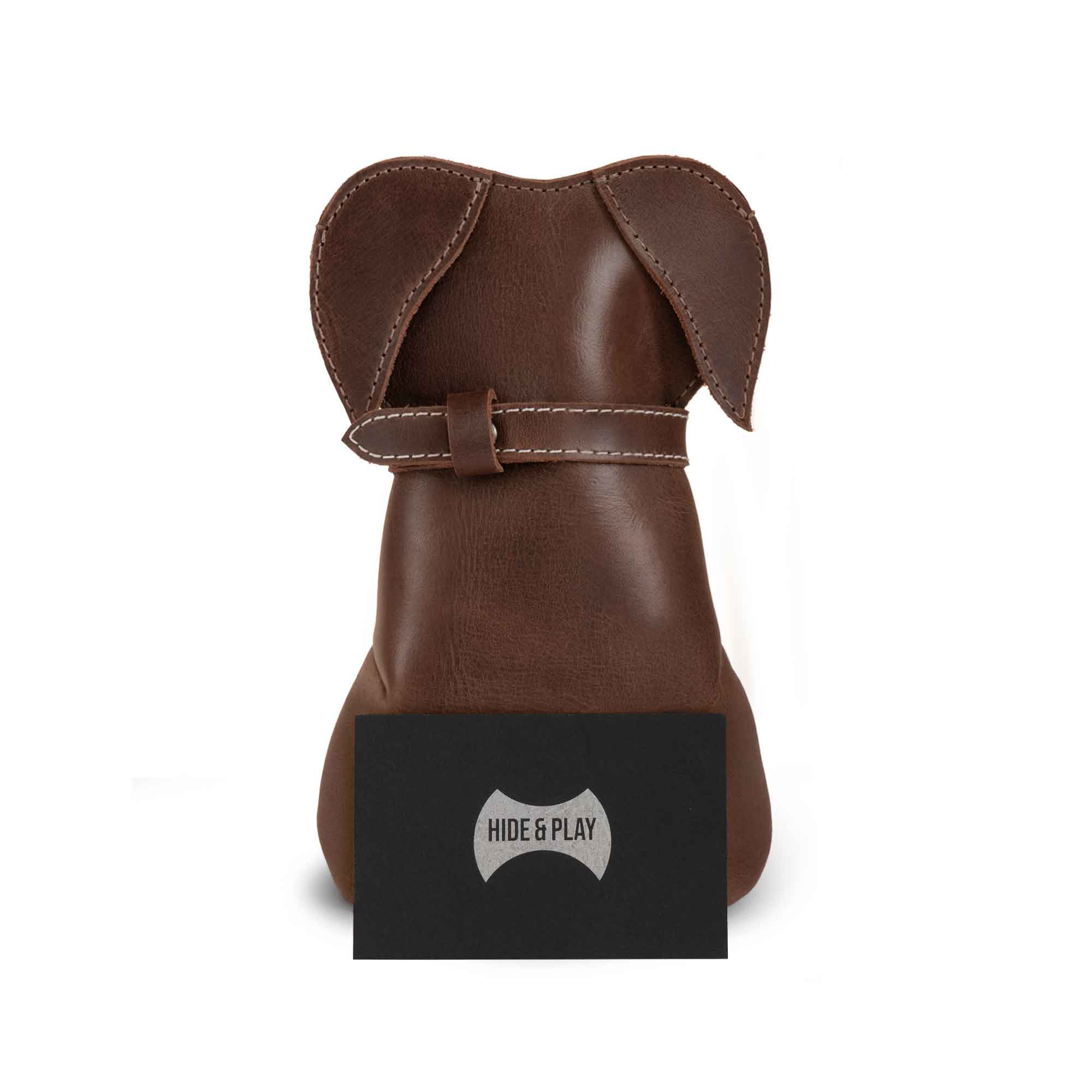 The Leather Doggy Pouch by Hide & Play displayed with its logo, highlighting its design as a Leather Doggy-Shaped Coin Pouch Piggy Bank. This stylish Cash Holder Organizer is perfect as a Coin Purse for Men & Women and functions as a Money Saving Box. Designed as a Small Mens Wallet for Coins, this pouch features artisanal craftsmanship made with Full Grain Leather, hand cut and hand sewn in La Antigua Guatemala and Oaxaca Mexico.