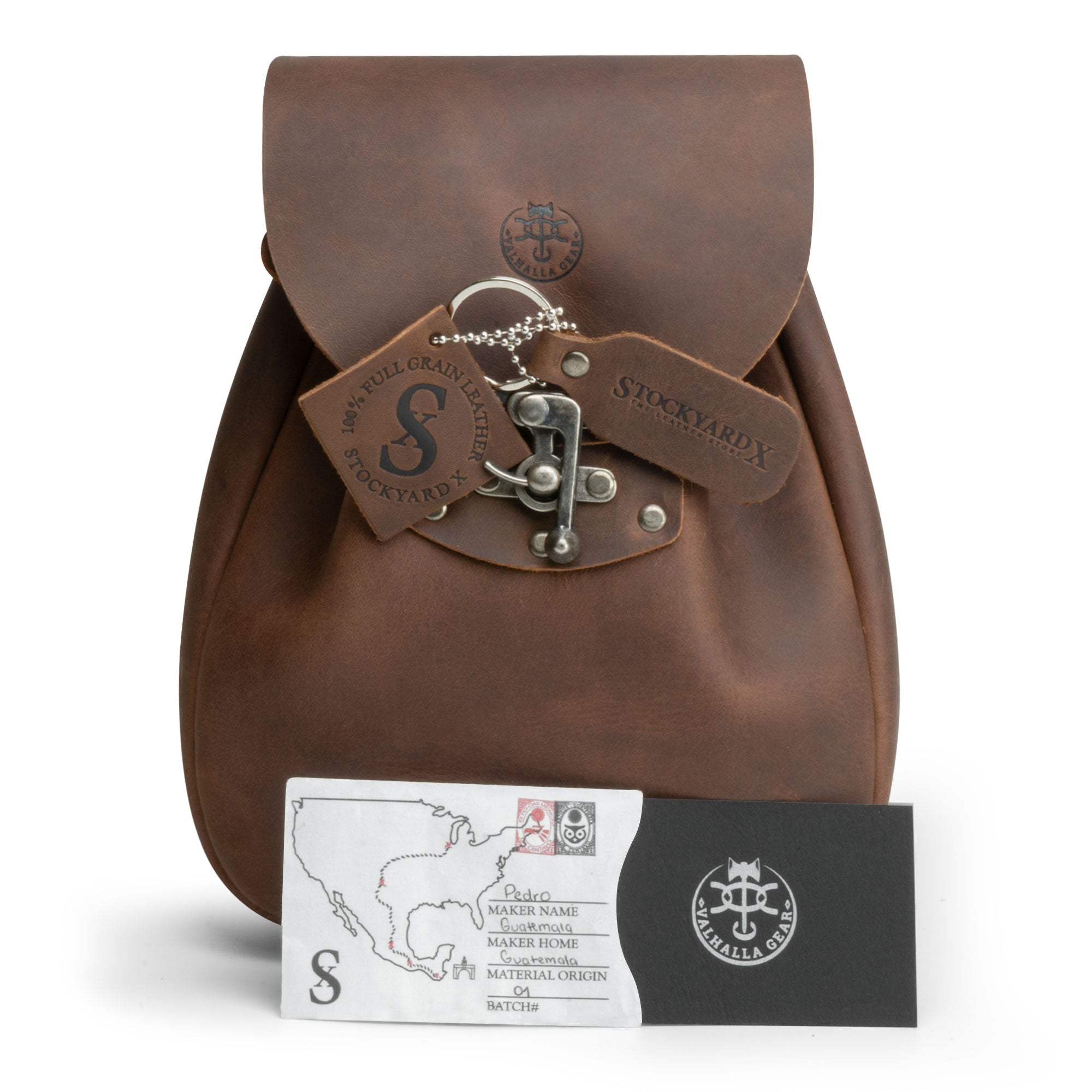 Packaging view of a Full Grain Leather Medieval Style Belt Bag by Valhalla Gear, featuring care and authenticity tags. This Waist Bag is ideal as a Camping Pouch for Essentials, showcasing meticulous Artisan craftsmanship with Small Batch Production, Hand Cut, Hand Sewn, and Fire Branded techniques, made in La Antigua Guatemala & Oaxaca Mexico.