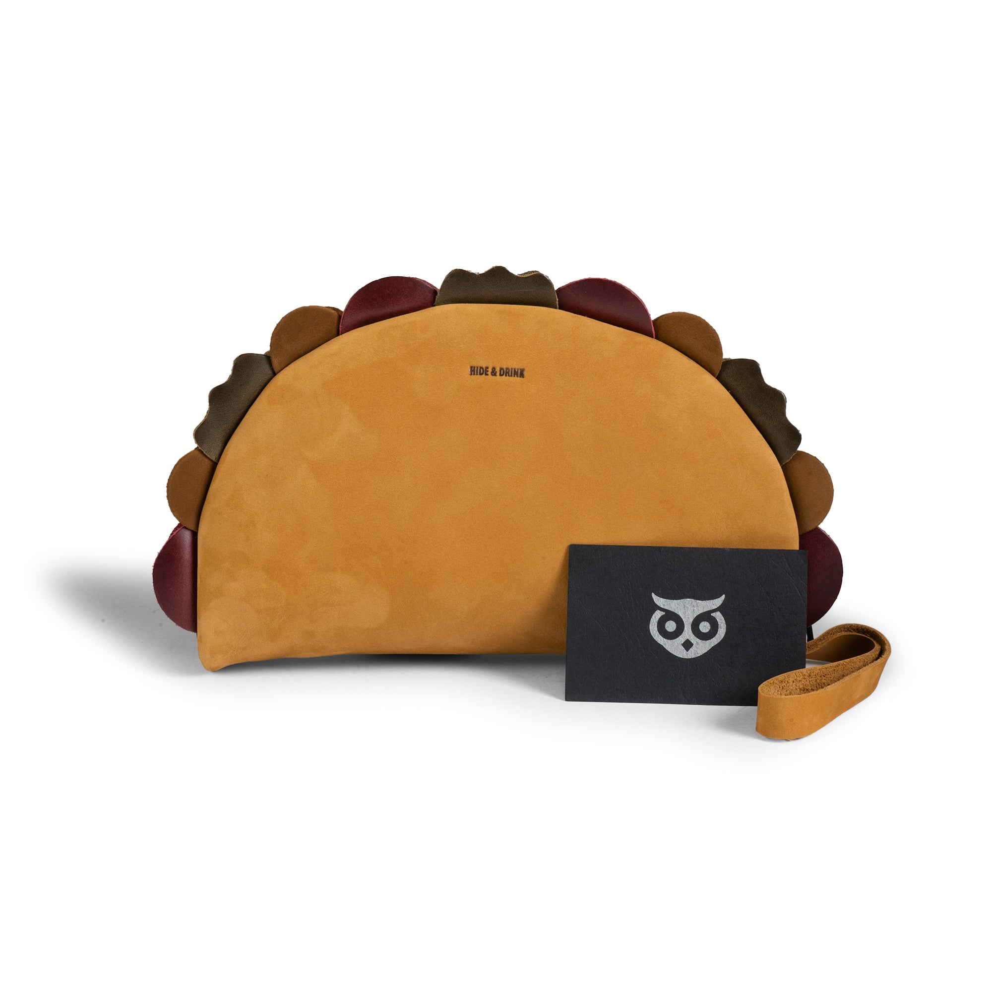 Hide & Drink Taco Clutch Bag displayed with its branded pouch and wrist strap; Taco Clutch Bag Full Grain Leather by StockyardX, made through Small Batch Production with Hand Cut, Hand Sewn, Fire Branded Artisan craftsmanship, Handmade in La Antigua Guatemala & Oaxaca Mexico.