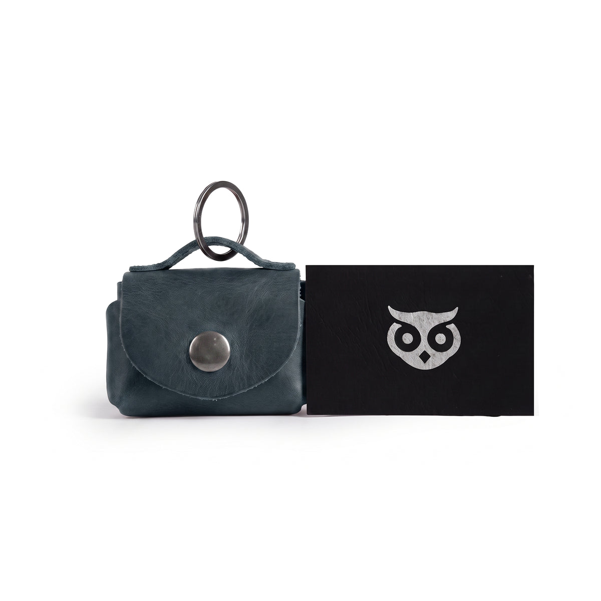 Top view of the Tiny Handbag Keychain by Hide & Drink combined with other leather goods, showcasing its handmade quality. Crafted from Full Grain Leather in small batches, this artisan piece from StockyardX fits perfectly in any collection of unique accessories.