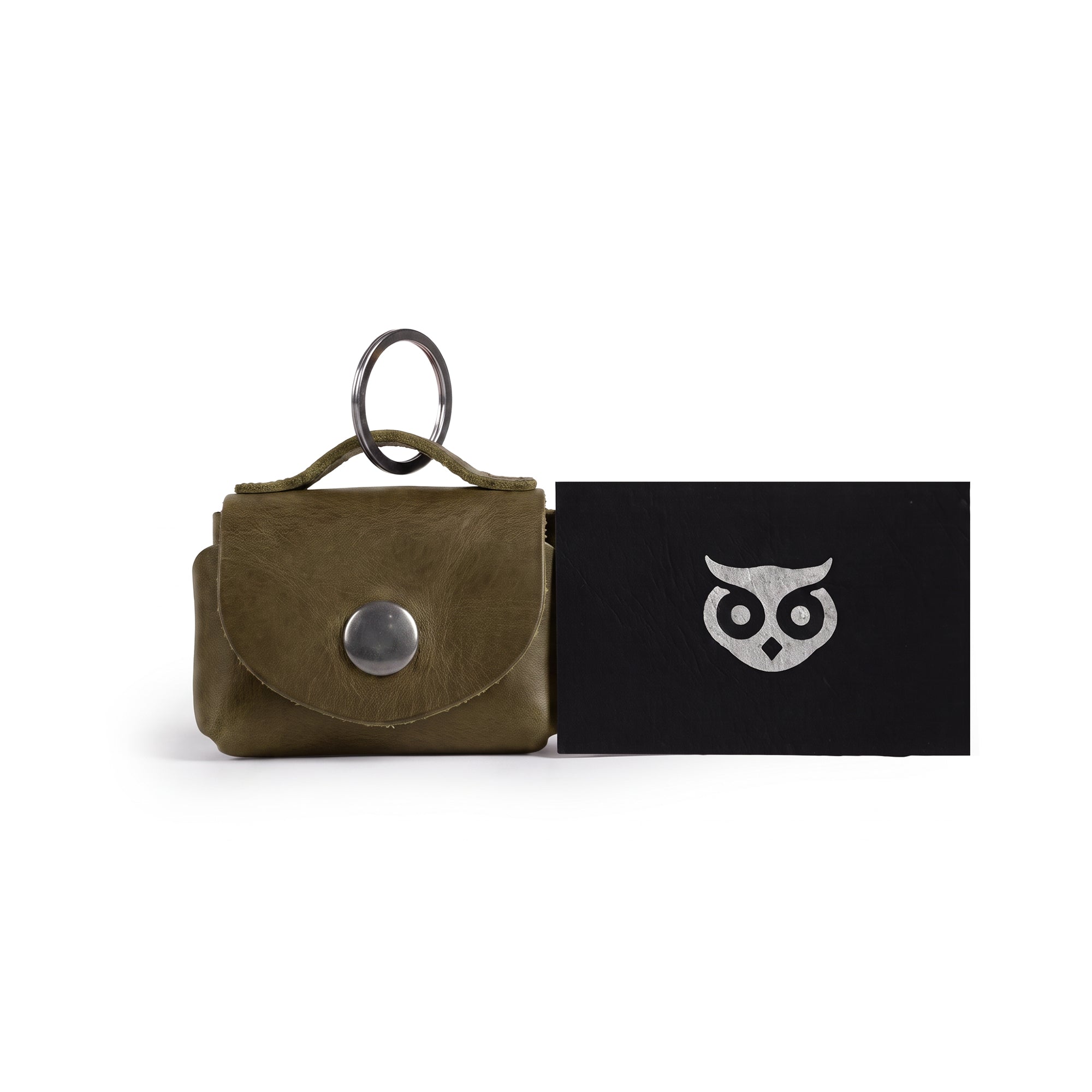 Top view of the Tiny Handbag Keychain by Hide & Drink, displaying the Tiny Handbag with Key Ring Holder along with its unique packaging. This product, crafted from Full Grain Leather, reflects Small Batch Production, is Hand Cut, Hand Sewn, and Fire Branded, highlighting its Handmade quality from La Antigua Guatemala & Oaxaca Mexico.
