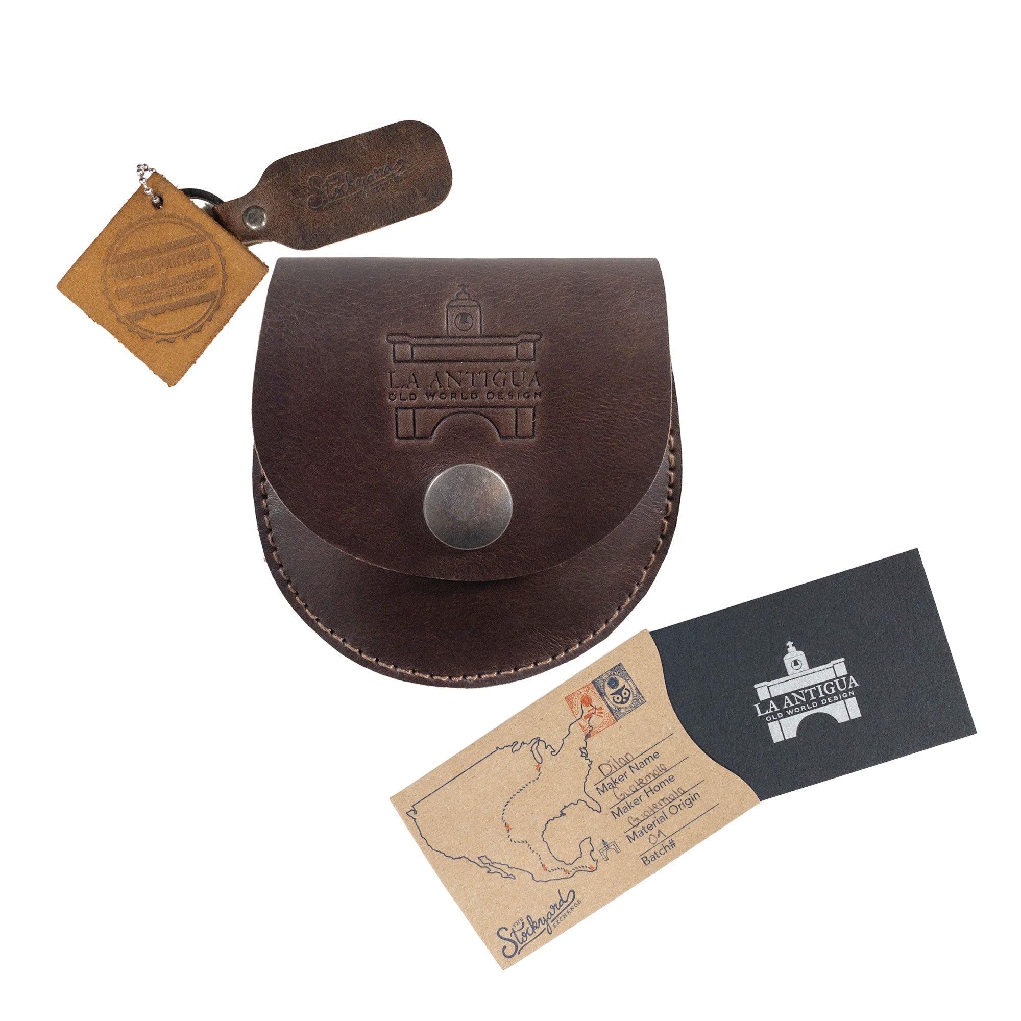 La Antigua Compass Case presented with care instructions and branding tags, showcasing its artisan quality and full grain leather. This classic pouch serves as a protective bag for outdoor accessories, hand cut and sewn in La Antigua Guatemala & Oaxaca Mexico, representing small batch production.
