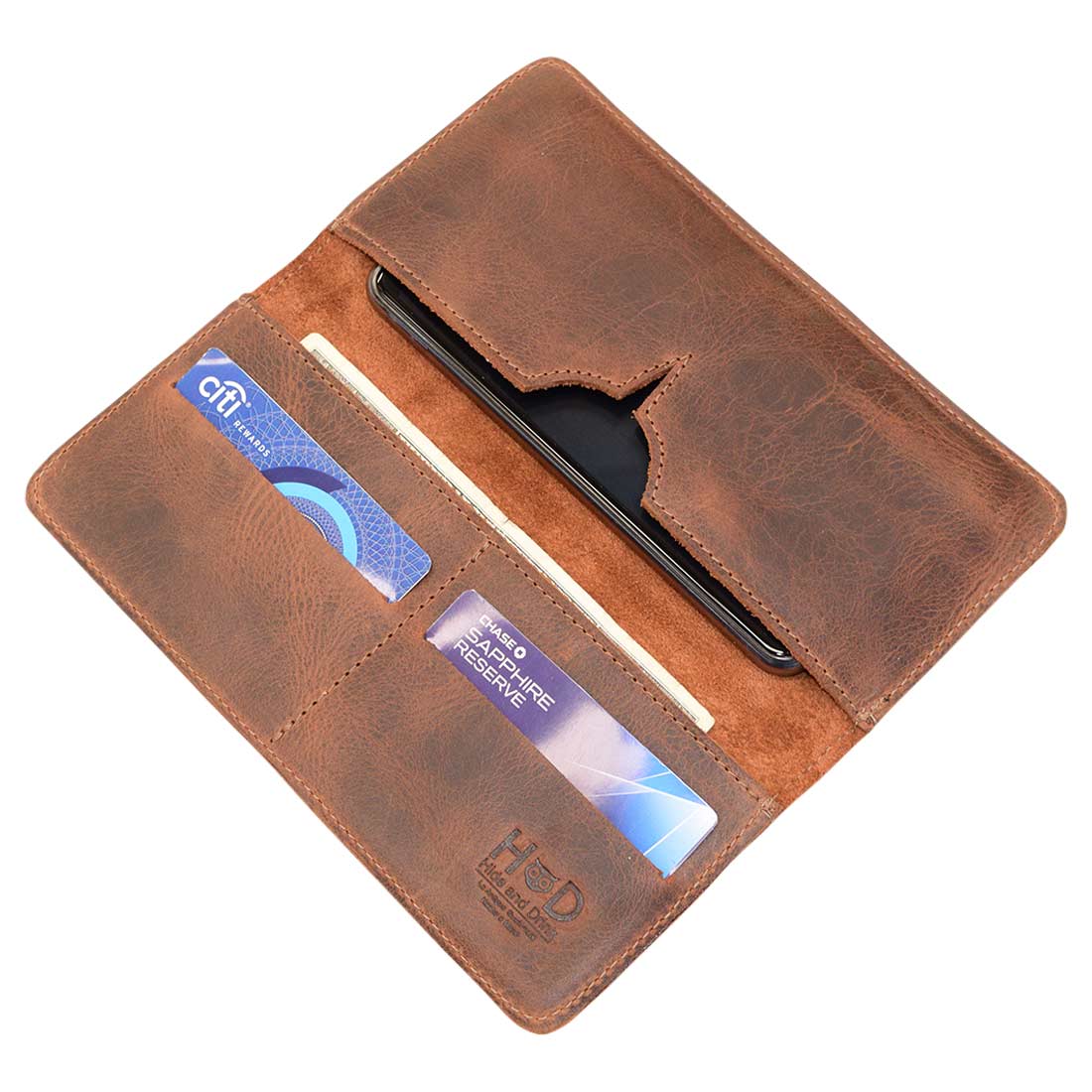 Open bifold wallet for cellphone by Hide & Drink, showcasing compartments for cards and a sleek design. This Bifold Wallet for Cellphone is made from Full Grain Leather, perfect for keeping your essentials organized. Enjoy the high-quality craftsmanship with features like small batch production and handmade in La Antigua Guatemala & Oaxaca Mexico.