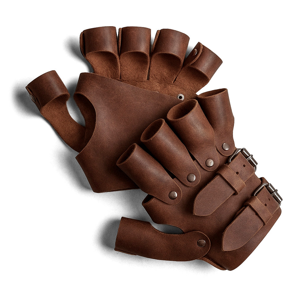 A close-up view of a pair of Set of 2 Steampunk Gloves, featuring adjustable straps and vintage design elements. Perfect for cosplay and costume accessories, crafted from full grain leather. Made by Hide & Play, these vintage gloves are part of their artisan collection, showcasing small batch production and handcrafted quality from La Antigua Guatemala.