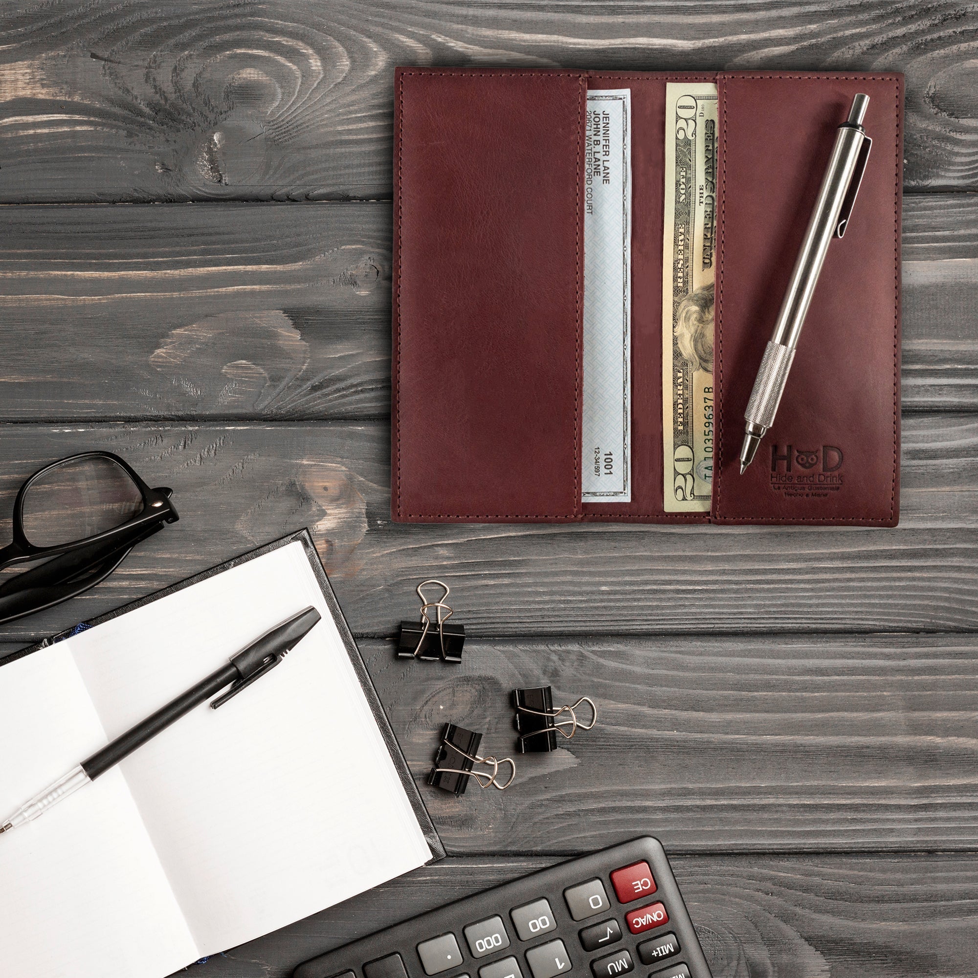 Checkbook Leather Cover by Hide & Drink featuring an artistic design, serving as a minimalist organizer for standard checkbooks. Crafted from full grain leather, this artisan product is handmade in La Antigua Guatemala and Oaxaca Mexico, emphasizing the techniques of small batch production.