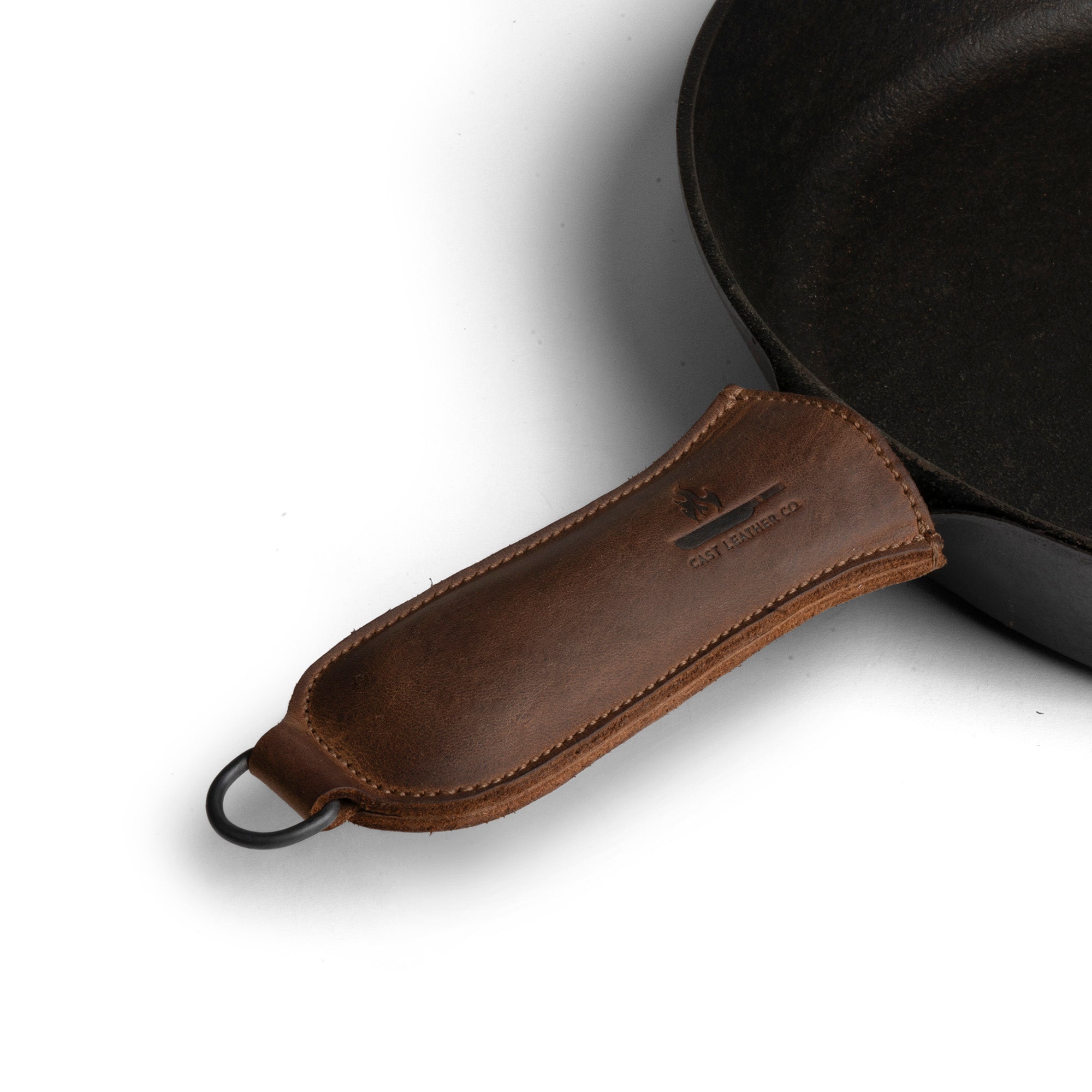 Hanging Pan Handle Cover by Cast Leather Co. showcasing a durable and stylish Hot Handle Panhandle with Half Ring, made from full grain leather, designed for cookware that slides on/off easily onto metal skillet grips. Perfectly hand cut and sewn, this artisan piece is a testament to small batch production, crafted in La Antigua Guatemala & Oaxaca Mexico.