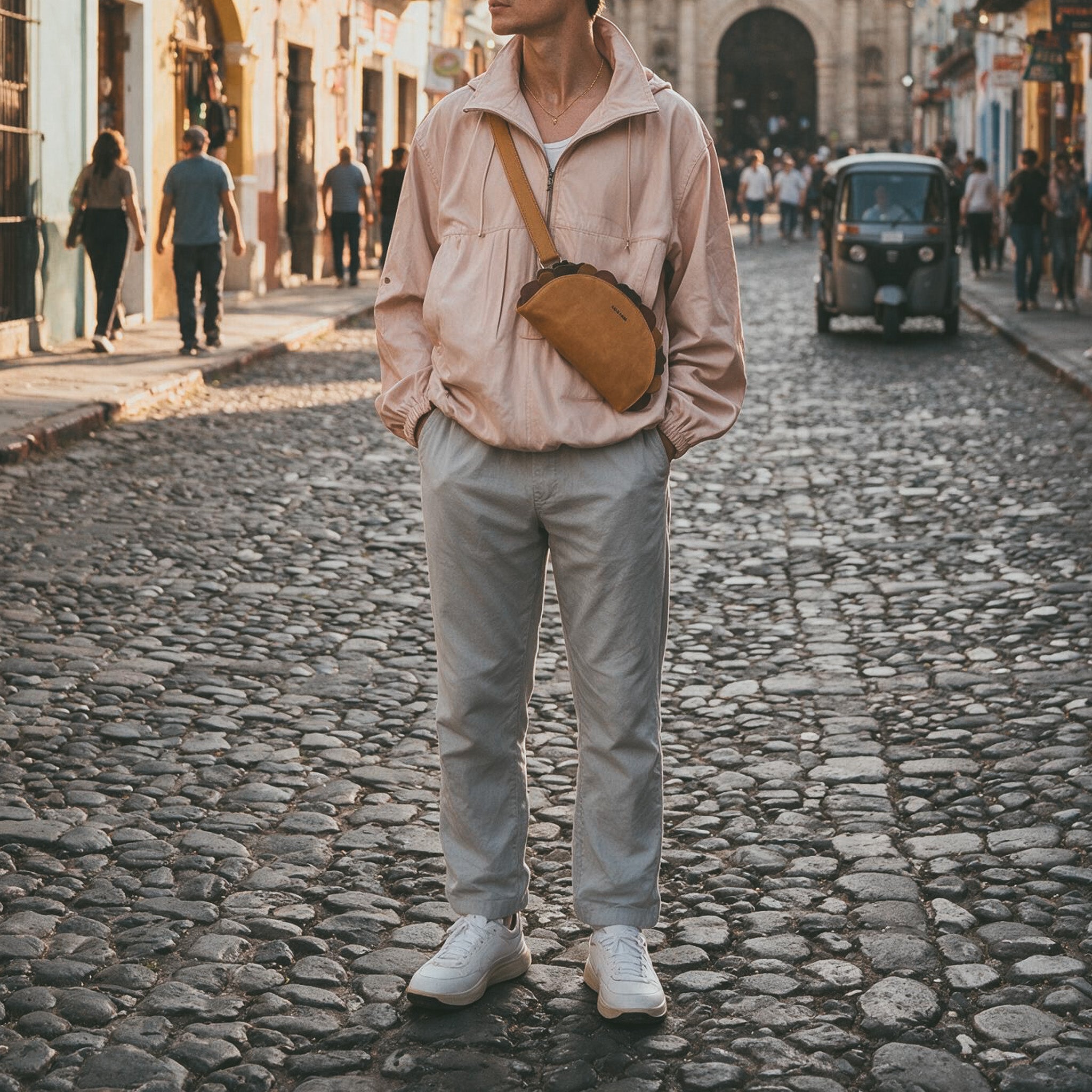 Lifestyle image of a woman enjoying ice cream while sporting the Taco-Shaped Crossbody Bag by Hide & Drink in a vibrant street setting. This Leather Taco-Shaped Crossbody Bag with Adjustable Shoulder Strap is the perfect accessory for casual outings, exemplifying exquisite craftsmanship as a messenger bag or shoulder bag, handmade in La Antigua Guatemala & Oaxaca Mexico.
