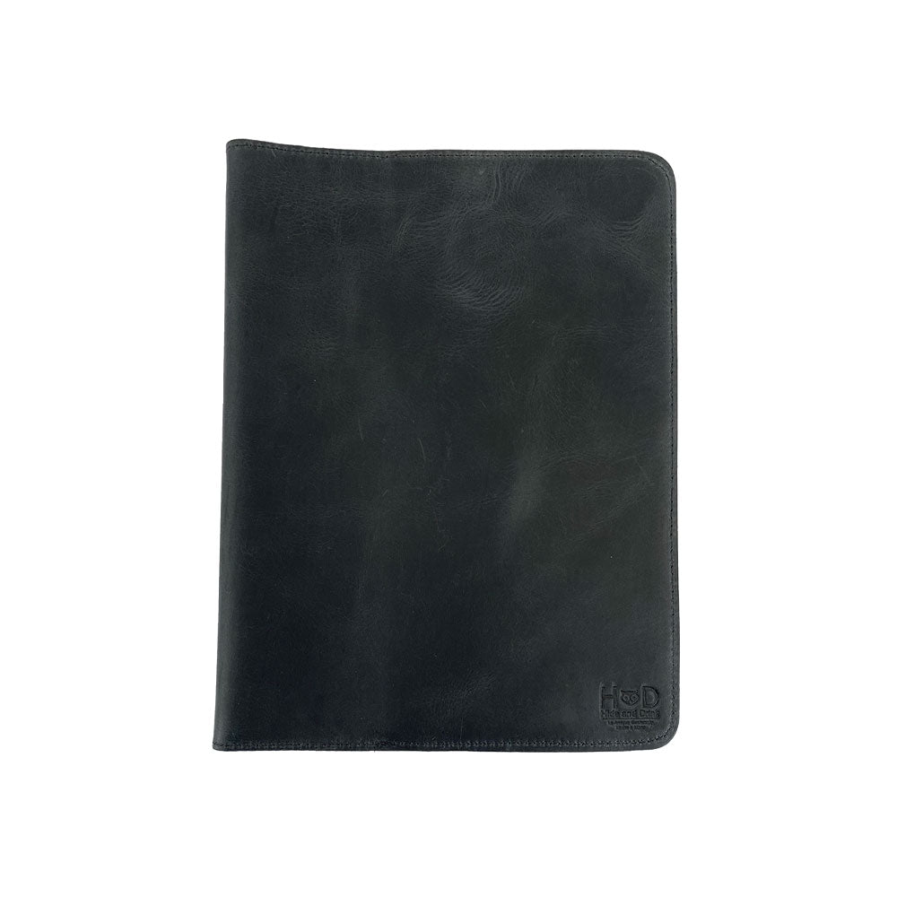 Front view of the black leather Full Grain Leather Journal Cover for Moleskine Cahier XL (7.5 x 9.75 in.) by Hide & Drink. Displaying a sleek finish, this handmade sleeve exemplifies the artistry in notebook cases, crafted with love in La Antigua Guatemala & Oaxaca Mexico.
