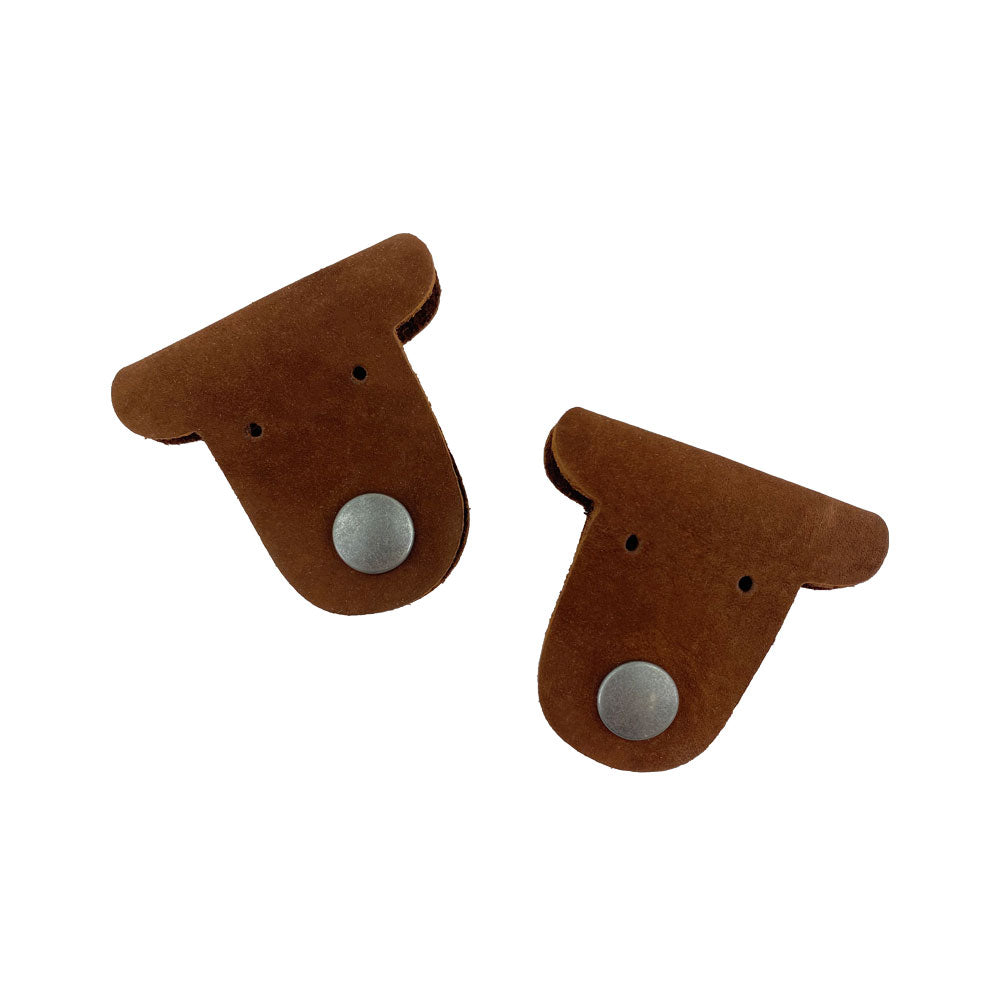 Two brown Dog Shaped Cord Keepers (2-Pack) by Hide & Drink, crafted from Full Grain Leather, perfect for managing cables at home or on the go. Dog Shaped Cord Keeper (Cord Clam) 2-Pack, Full Grain Leather, StockyardX, Small Batch Production, Hand Cut, Hand Sewn, Fire Branded, Artisan, Handmade in La Antigua Guatemala & Oaxaca Mexico.