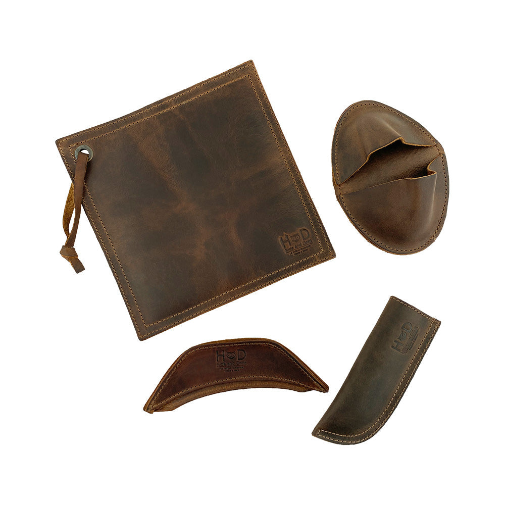 Hide & Drink Hot Handle Holders (Set of 4) showcase a stylish set featuring a Panhandle and Side Kick, along with a Grip Mitt and Square Pot Holder, designed for cast iron skillets and pans. Made from durable Full Grain Leather, these Hot Handle Holders are crafted in small batch production, hand cut and hand sewn, ensuring quality. Artisan-made in La Antigua Guatemala & Oaxaca Mexico, they are fire branded for an authentic touch.