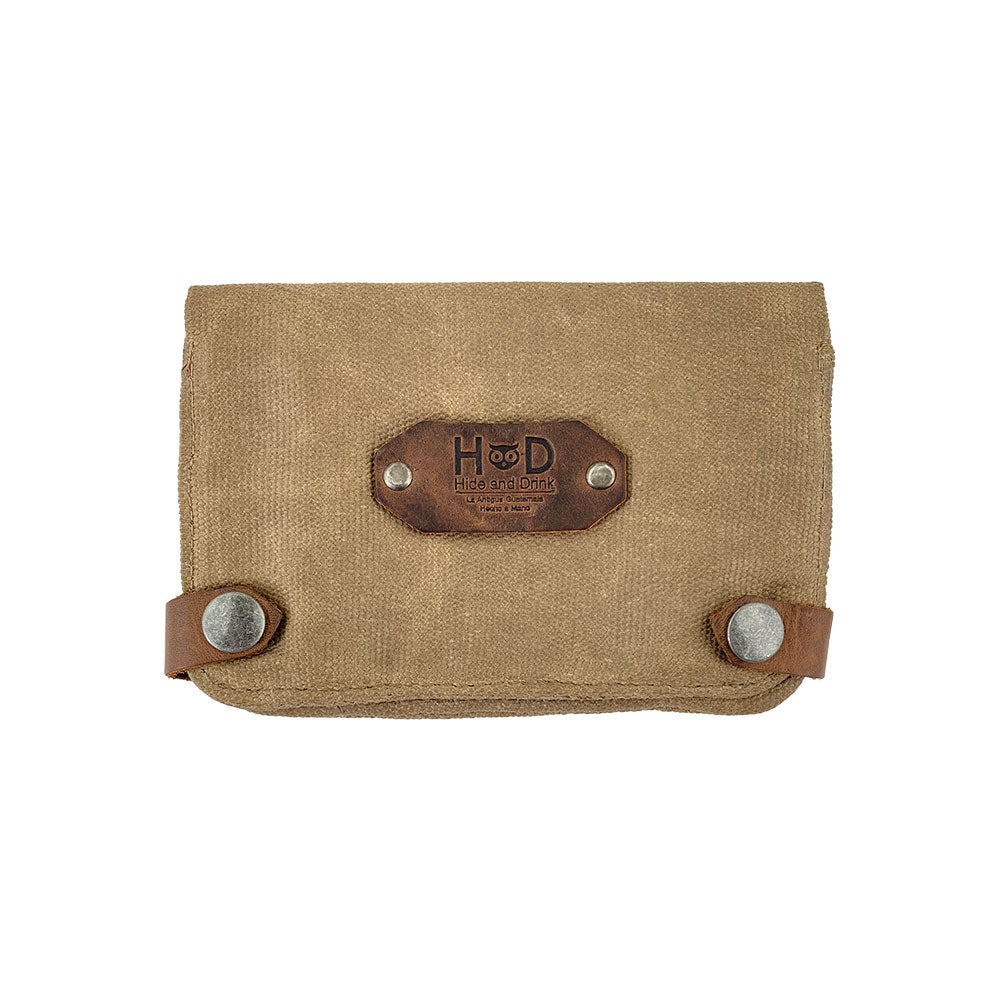 Hide & Drink Tobacco Pouch Waxed Canvas features a sturdy design with snap closures, perfect for storing tobacco and field notes. A must-have travel essential, this classic storage solution showcases small batch production, handmade craftsmanship, and artisan quality from La Antigua Guatemala.