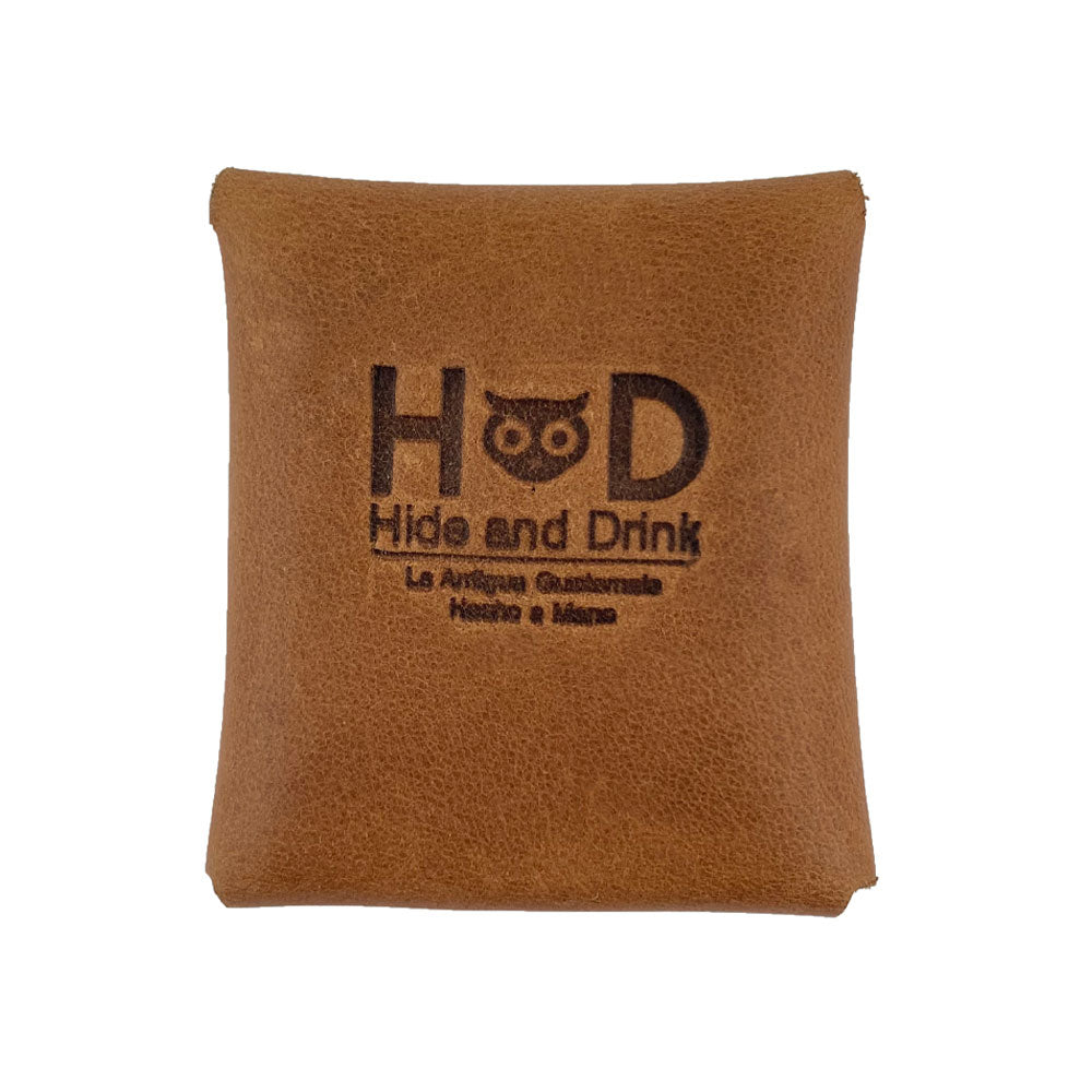 Back view of a light brown Minimalist Square Coin Pouch by Hide & Drink, featuring the brand logo. This finely crafted leather pouch exemplifies artisan quality and simplicity, making it a stylish addition to any collection. Minimalist Coin Pouch, SD Card Holder, Wallet and Cash Organizer, Full Grain Leather, StockyardX, Small Batch Production, Hand Cut, Hand Sewn, Fire Branded, Artisan, Handmade in La Antigua Guatemala & Oaxaca Mexico.