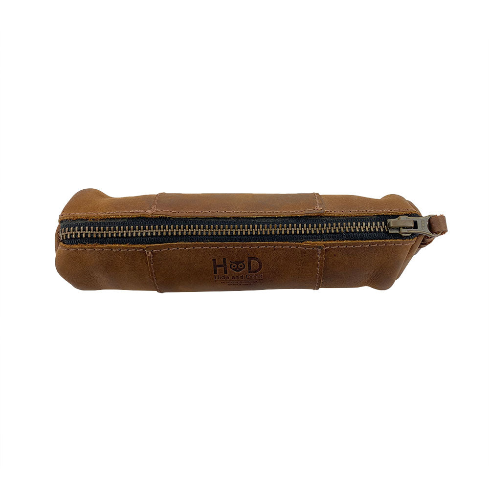 Side view of the Utility Cylinder Case by Hide & Drink showcasing the durable YKK zipper. This handmade and artisan-crafted bag is perfect for organizing personal items and office supplies. Cylinder Case, Classic Bag, Handmade, Rustic, Full Grain Leather.