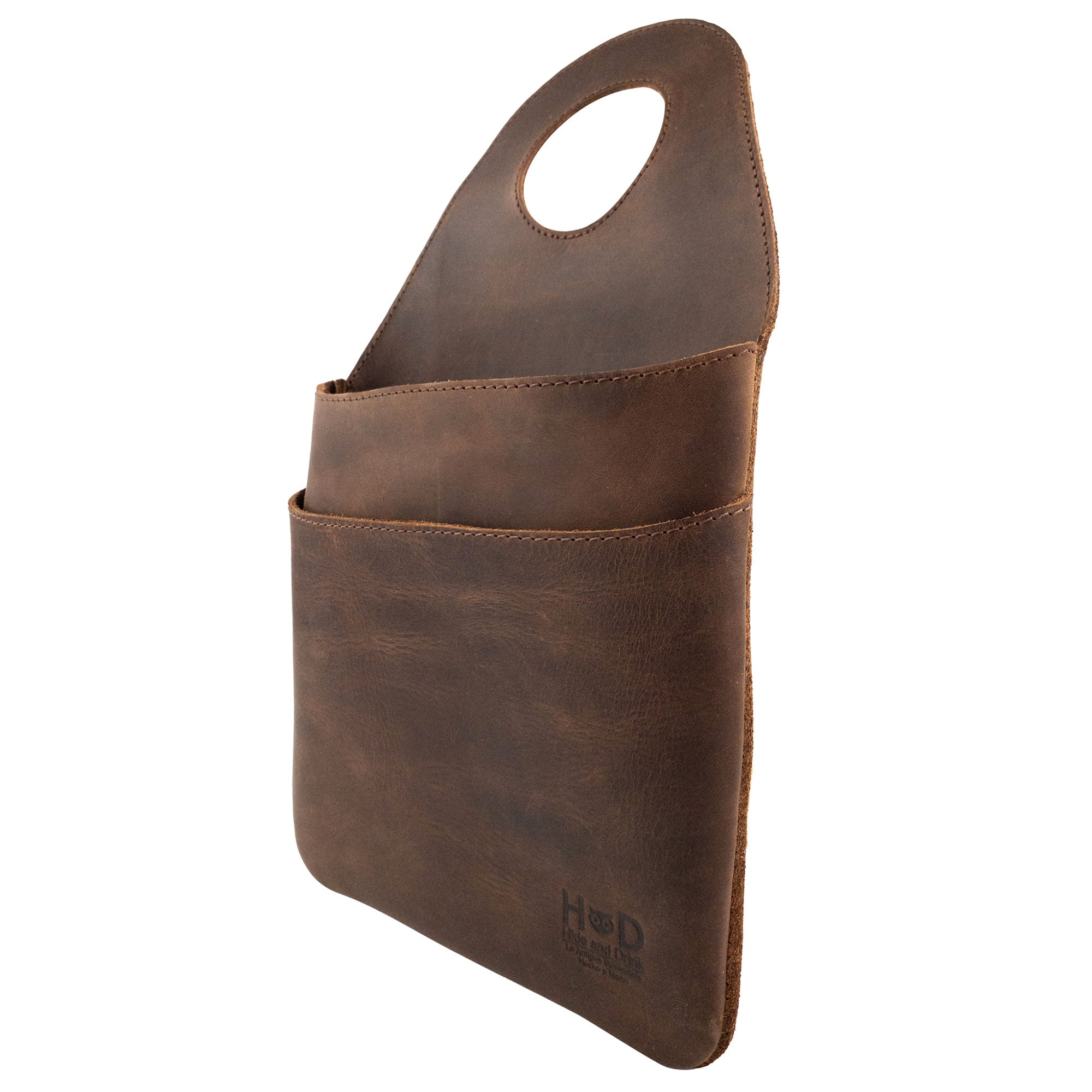 Side view of Hide & Drink's Seat Side Organizer for Gear Stick presenting its sleek design in Full Grain Leather. This organizer effectively holds charges, cables, and essentials while serving as an outdoor protector for knives. Crafted with expertise in small batch production, it is hand cut, sewn, and fire branded by artisans in La Antigua Guatemala & Oaxaca Mexico.