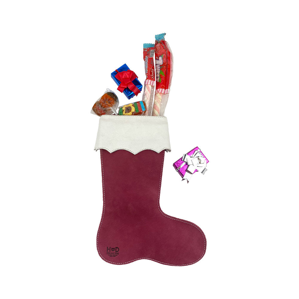 The Hide & Drink Christmas Stocking Boot with festive candies spilling out, representing a joyful holiday spirit. This suede leather stocking exemplifies traditional craftsmanship, making it an ideal choice for Santa Stocking Decorations.