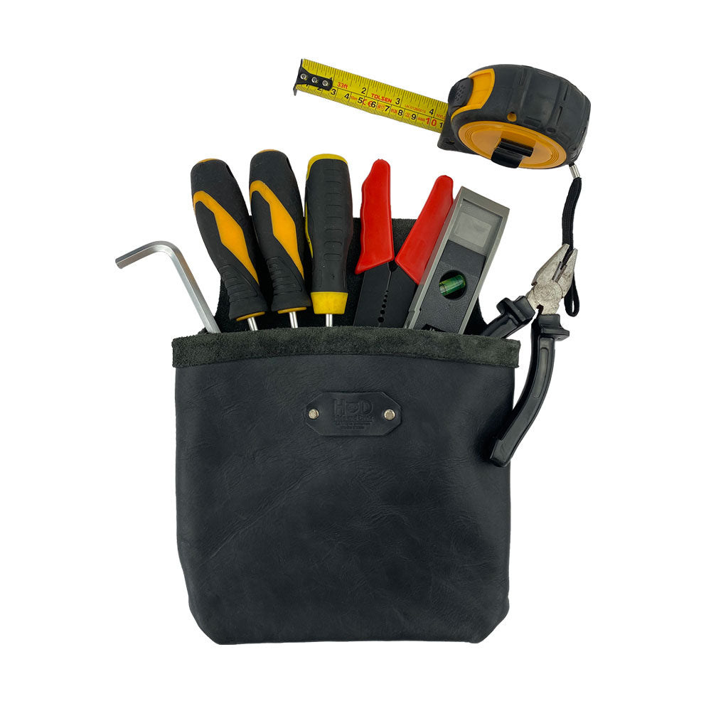 Constructor Belt Bag in black by Hide & Drink filled with tools, made for constructors. This tool bag boasts a large pocket and is crafted from full grain leather, showcasing artisan craftsmanship from La Antigua Guatemala & Oaxaca Mexico.