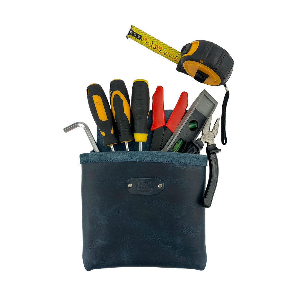 Constructor Belt Bag in slate blue by Hide & Drink filled with tools, perfect for constructors. This tool bag includes a large pocket and is made from durable full grain leather, demonstrating artisan craftsmanship from La Antigua Guatemala & Oaxaca Mexico.